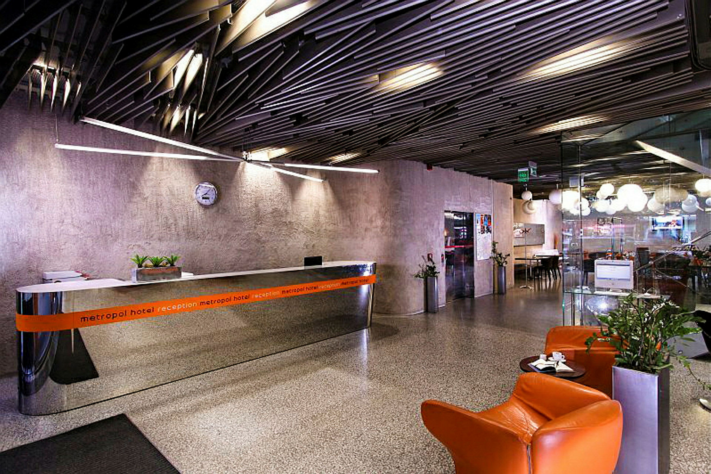 Hotellets reception og lobby med siddepladser og plantepynt. (AI-genereret tekst)