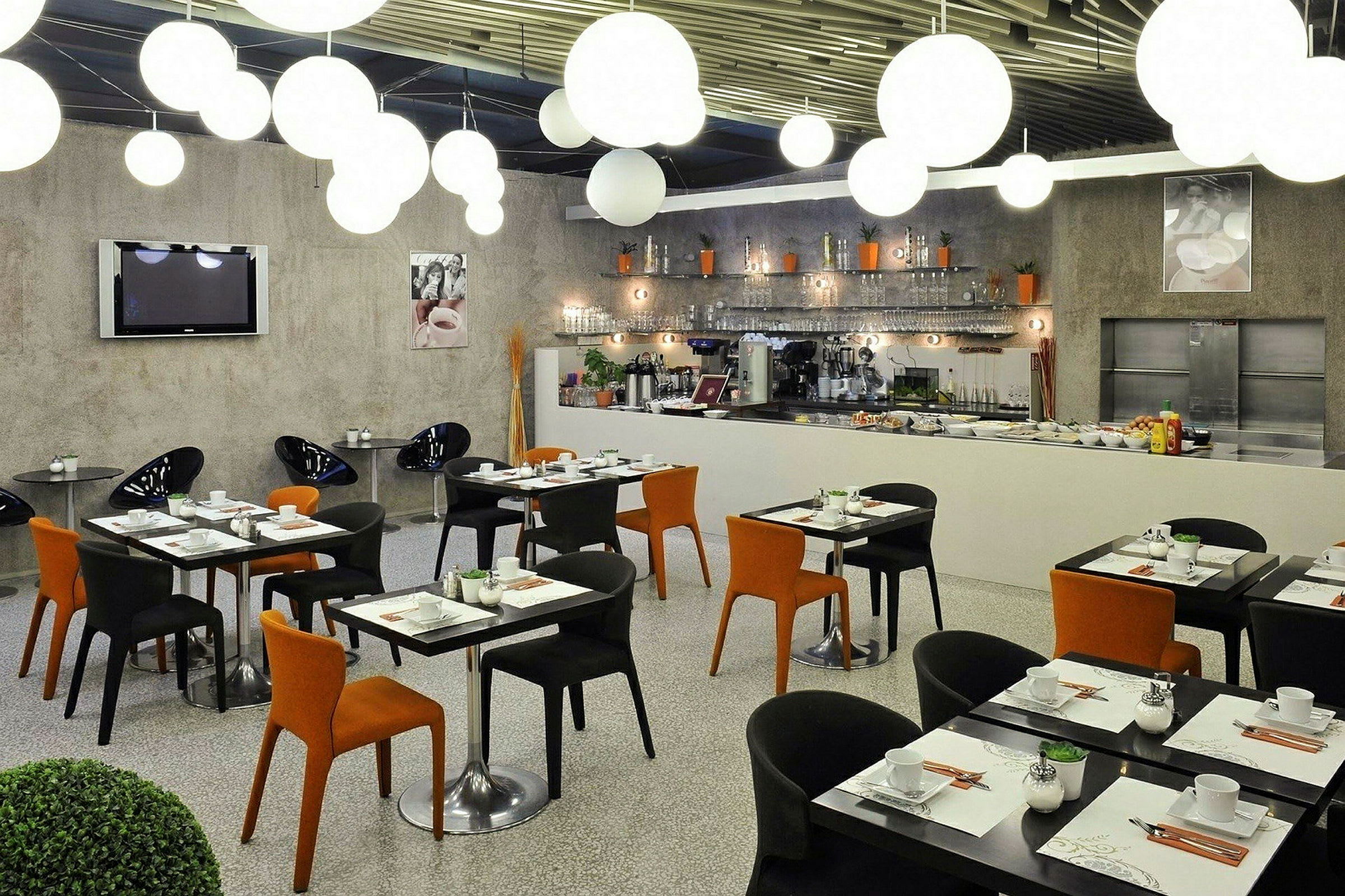 Moderne restaurantmøbler med sorte og orange stole samt dækkede borde. (AI-genereret tekst)