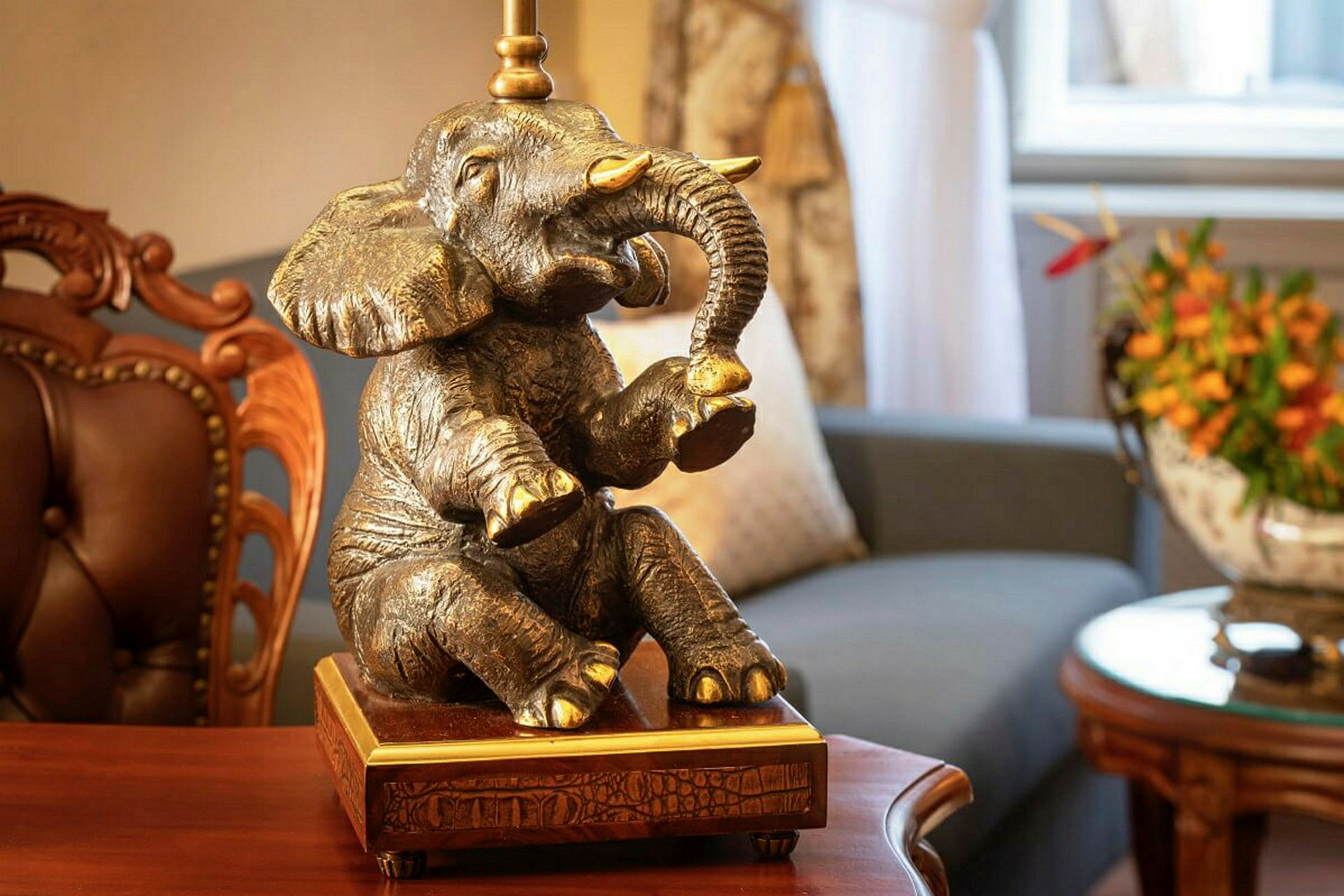 En dekorativ lampe i form af en elefant placeret i et rum med møbler. (AI-genereret tekst)