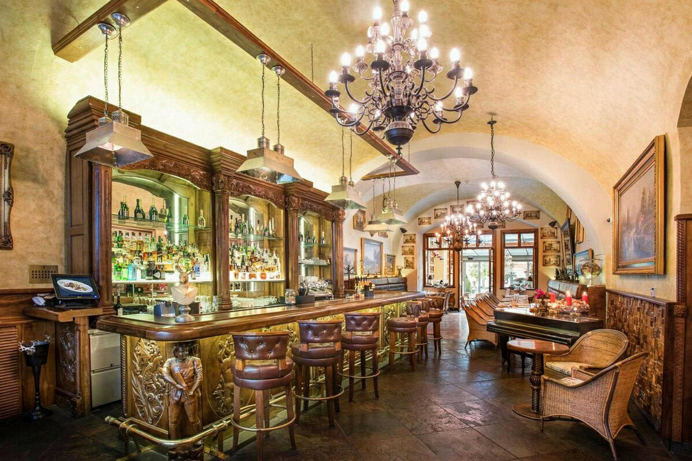 Et elegant interiør af en bar med luksuriøse møbler, loftslamper og et veludstyret barområde. (AI-genereret tekst)