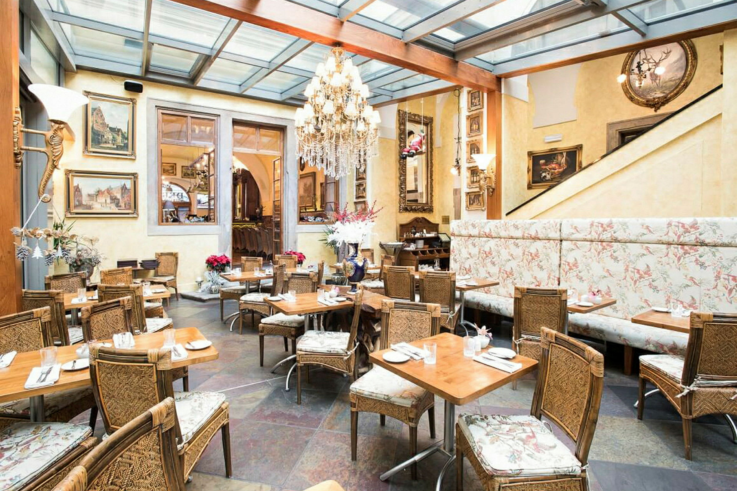 Elegant indrettet restaurant med panorama-tag, vægmalerier og rustikke siddepladser. (AI-genereret tekst)
