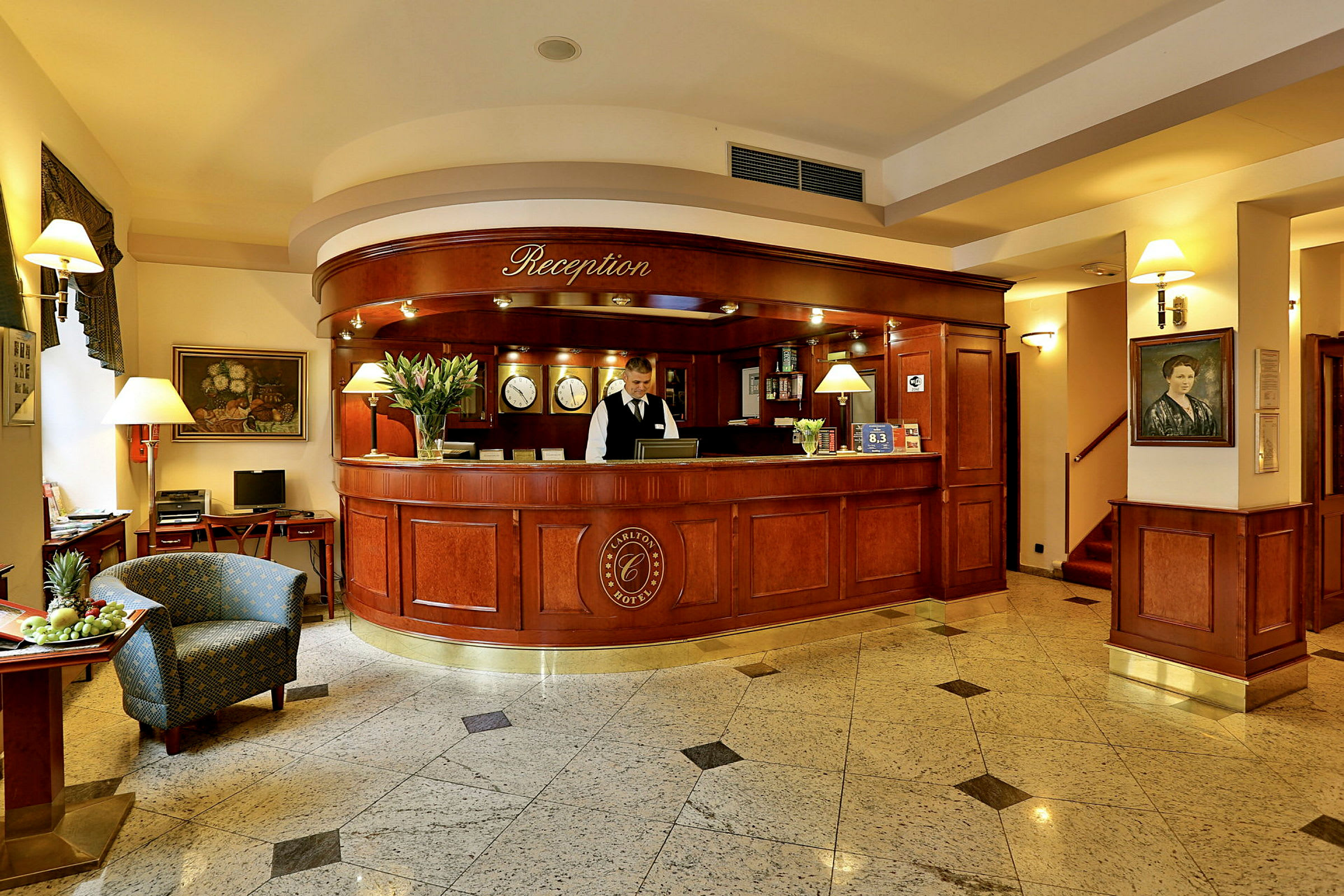 Receptionen på et hotel med en elegant træskranke, en receptionist, en stol og en skål med frugt. (AI-genereret tekst)