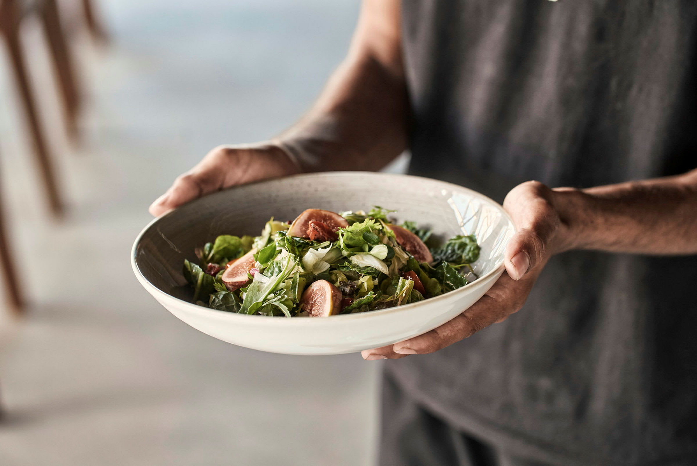En person holder en skål med salat. (AI-genereret tekst)