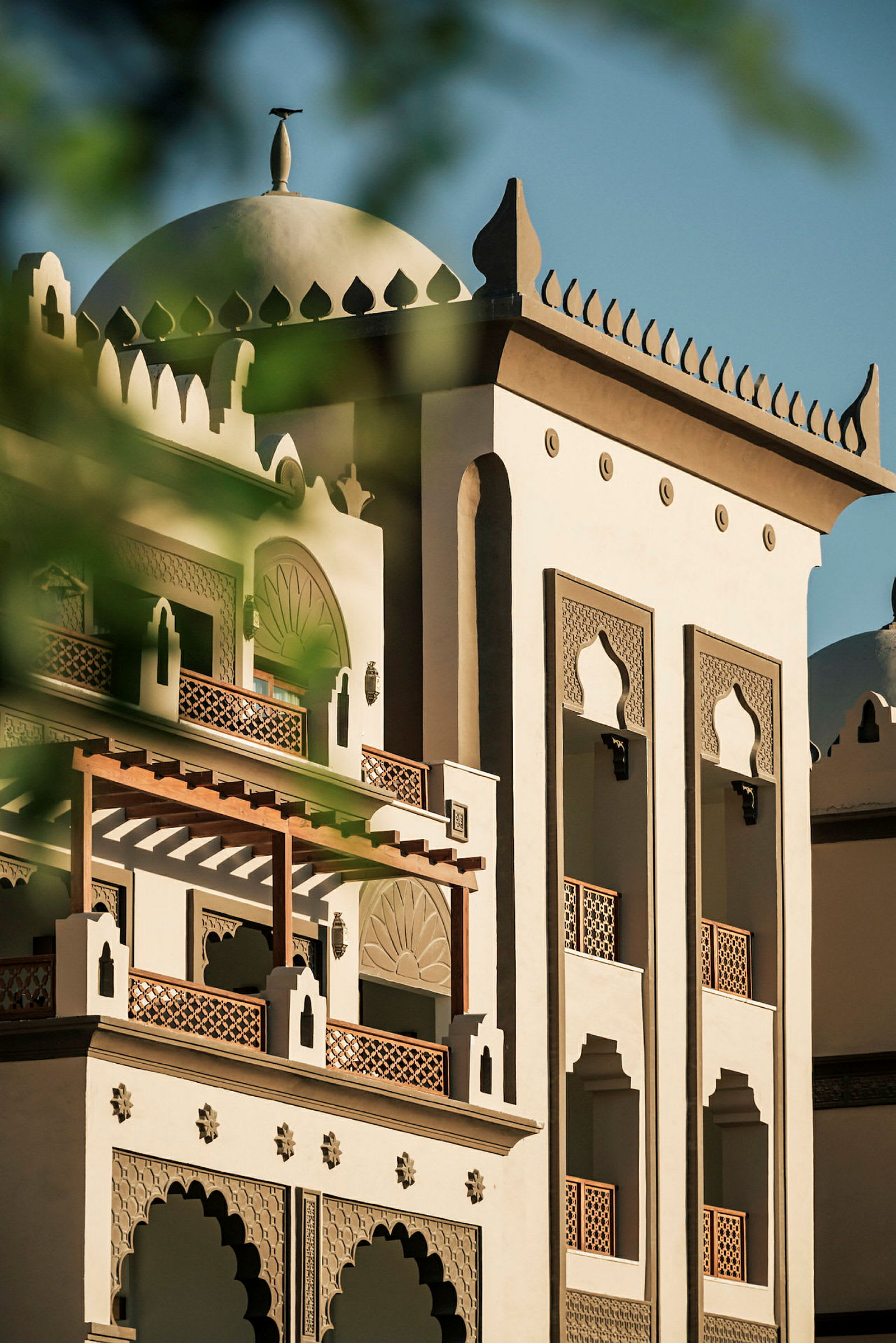 En bygning med arkitektoniske detaljer i arabisk stil, med kuppel og dekorative vinduer. (AI-genereret tekst)