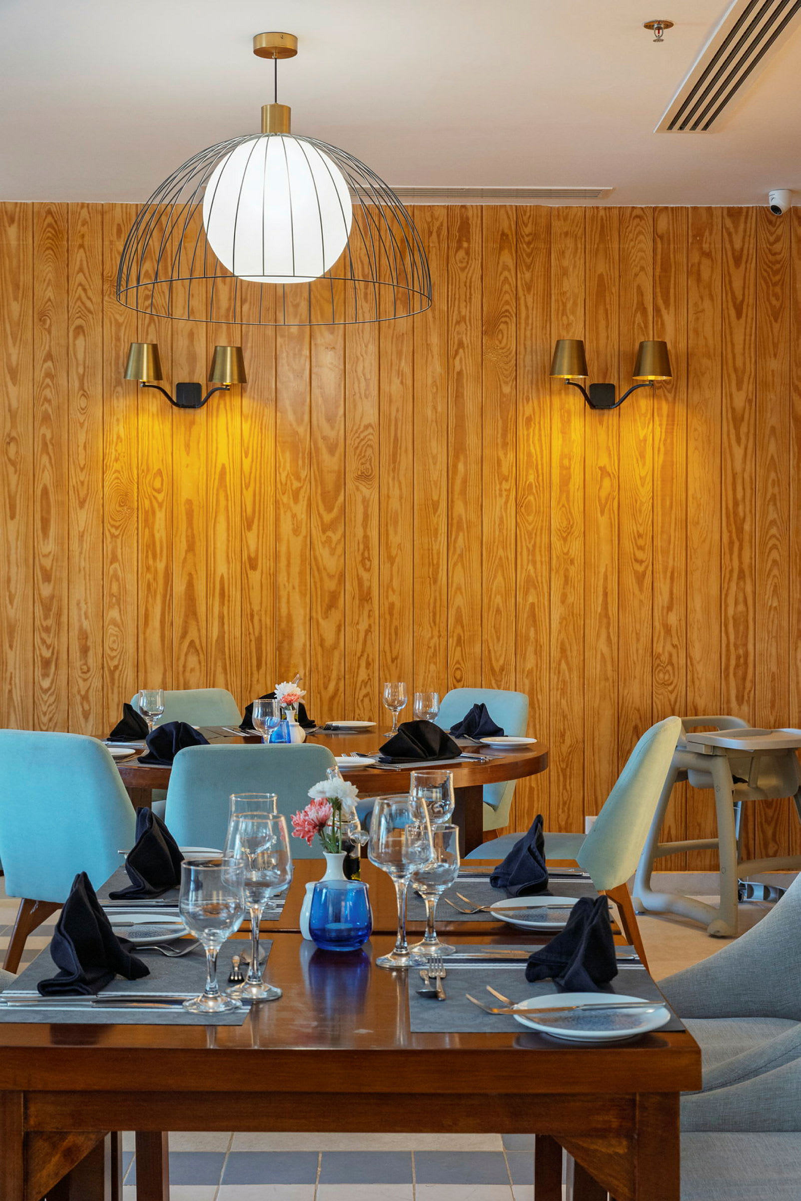Interiør af en restaurant med trævægge, opdækkede borde og stole. (AI-genereret tekst)