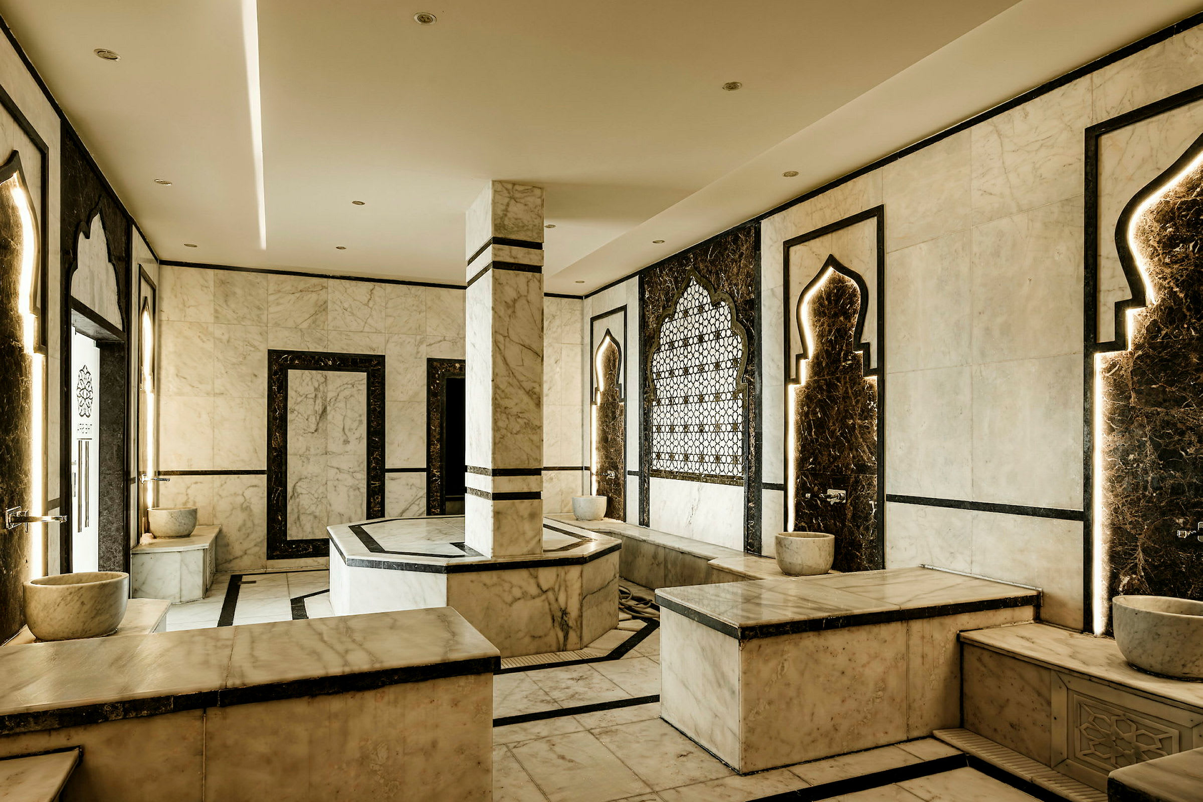 Et rum i traditionel hamam-stil med marmorinventar, dekorative motiver og bænke. (AI-genereret tekst)