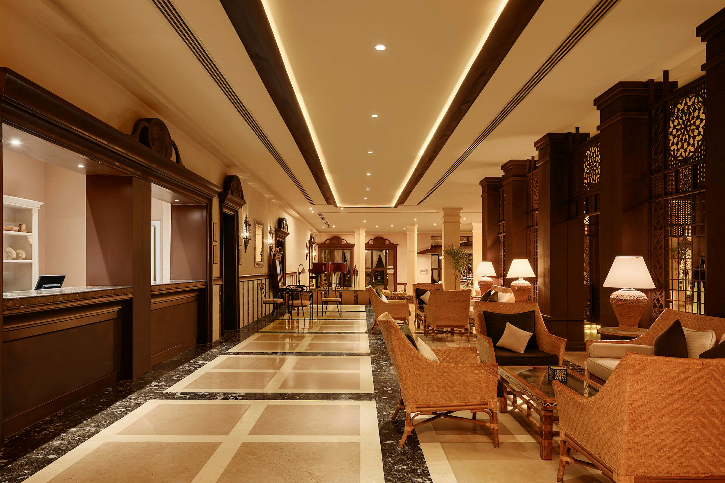 En hotellobby med siddepladser, borde og lamper. Receptionen er til venstre. (AI-genereret tekst)