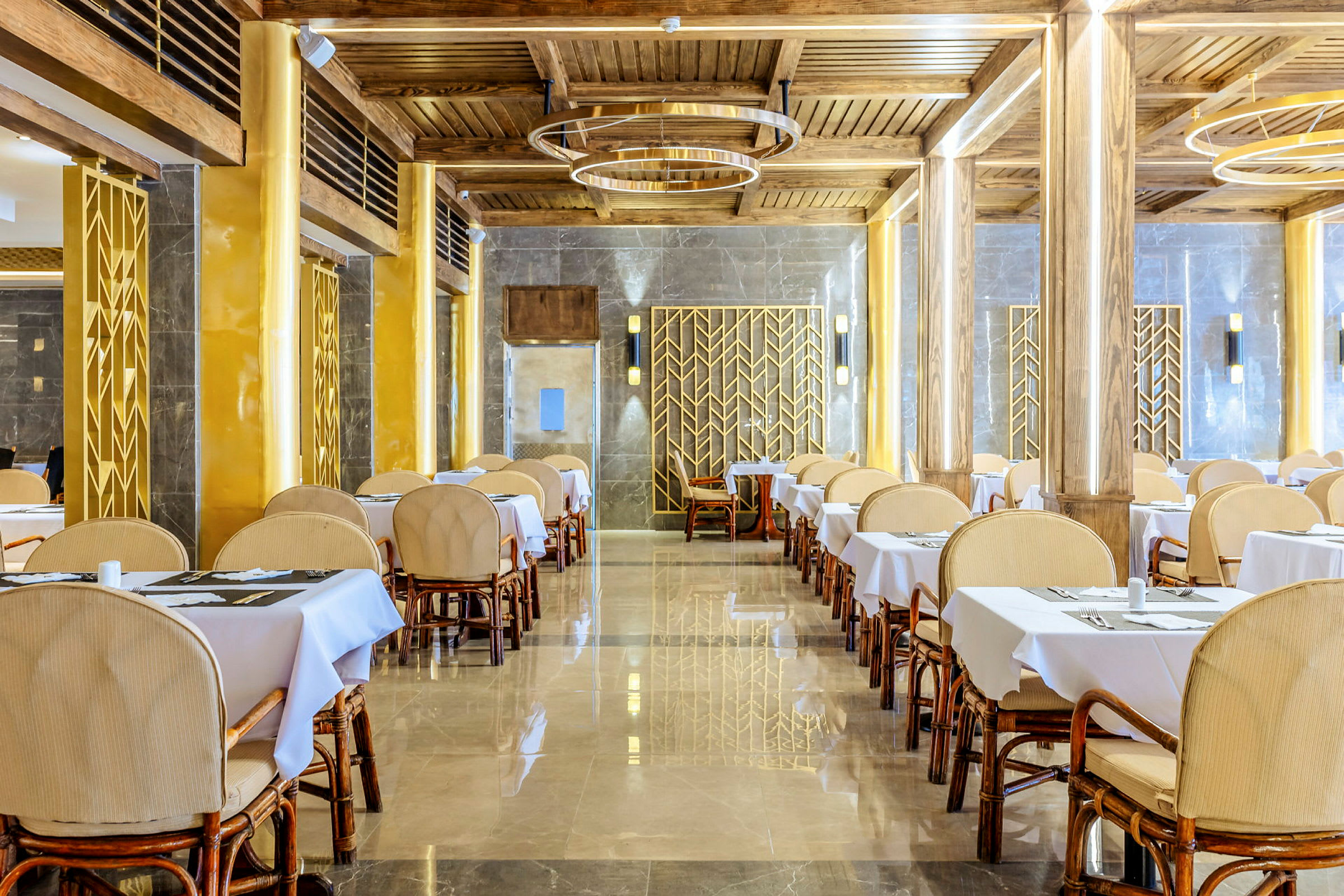 Interiør af en restaurant med borde og stole samt elegant udsmykning. (AI-genereret tekst)