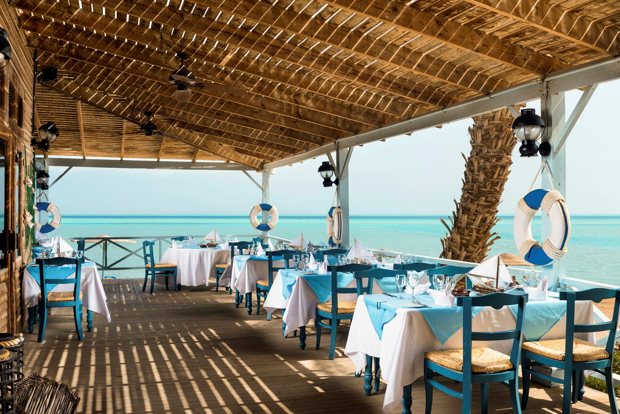 En restaurant med blå og hvide farver ved havet. (AI-genereret tekst)
