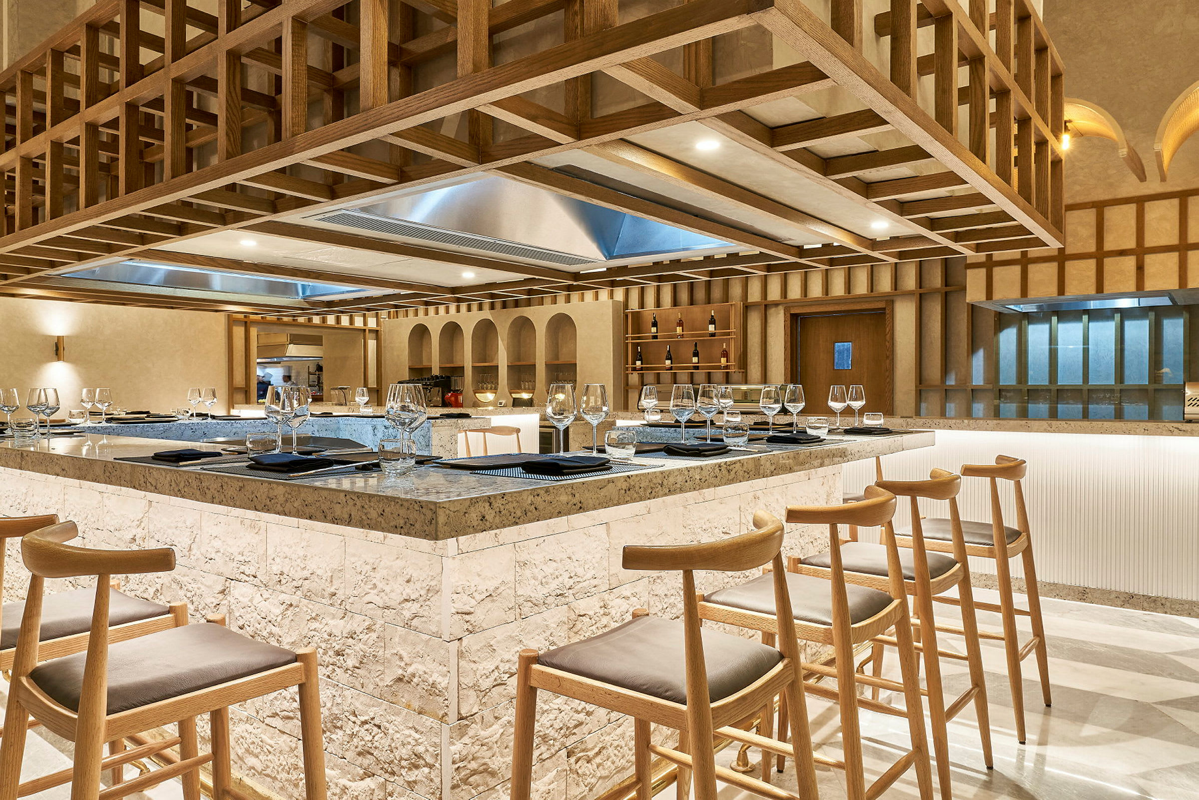 En elegant restaurant med en central bardisk omgivet af høje træstole. (AI-genereret tekst)