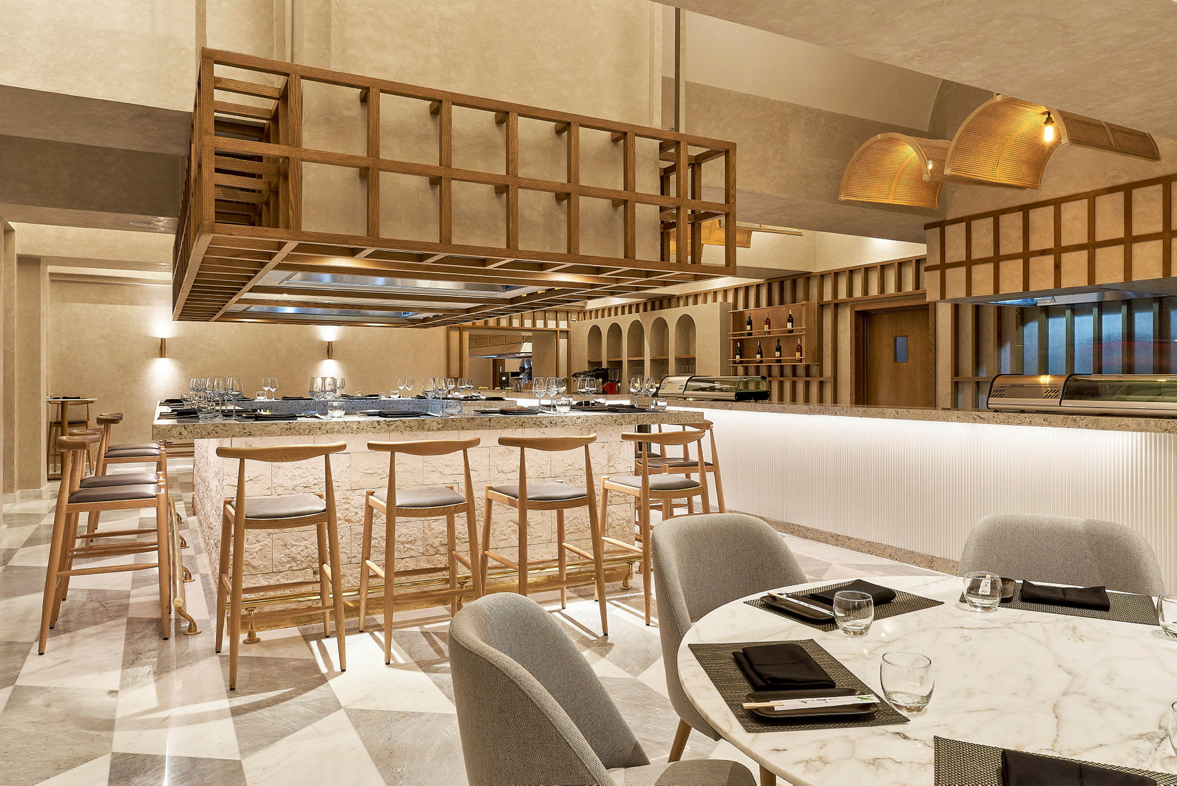 Et moderne restaurantområde med en centralt placeret bardisk og barstole. (AI-genereret tekst)