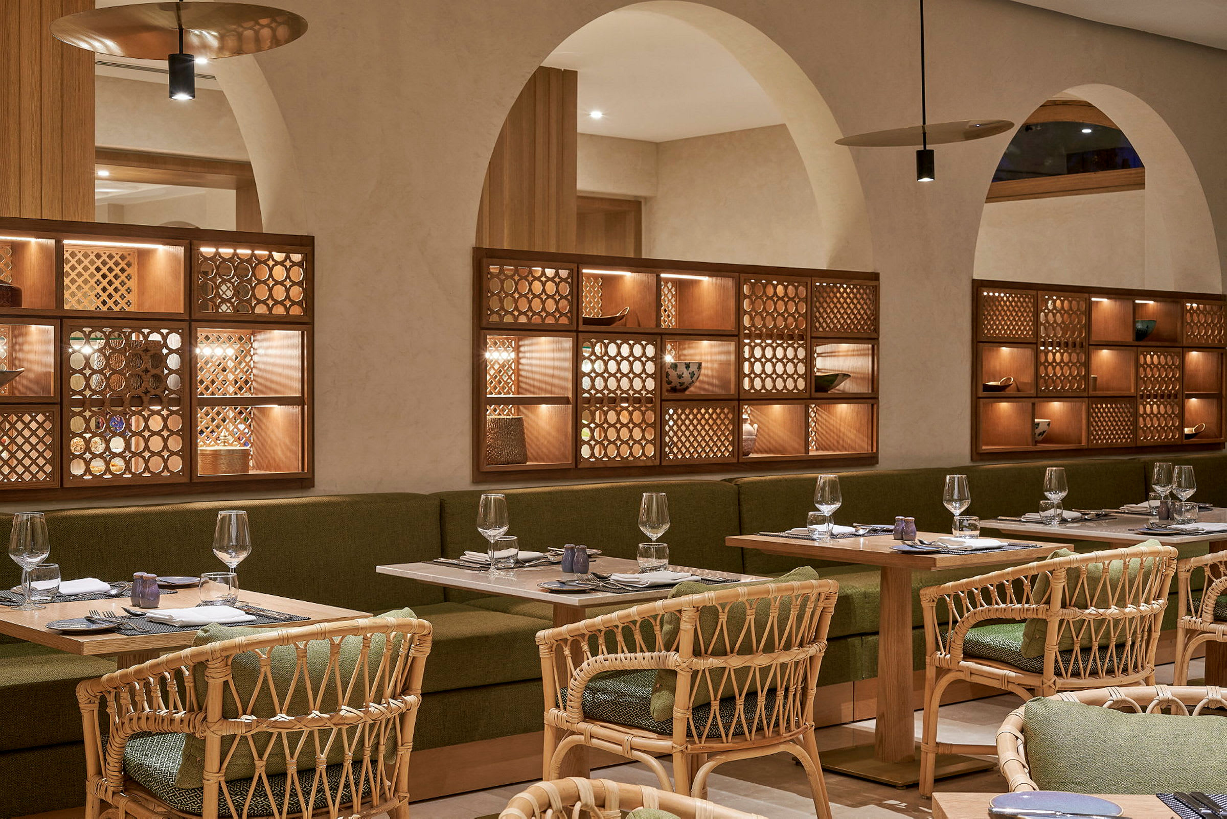Indendørs billede af en restaurant med borde, stole og interiør af træ og grønt stof. (AI-genereret tekst)