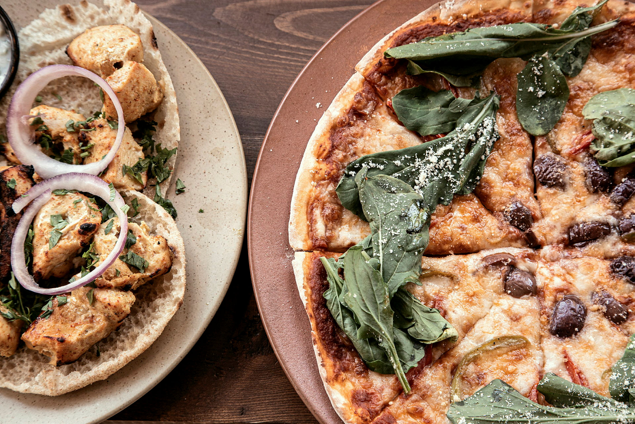 Madbillede der viser kyllingwraps og pizza. (AI-genereret tekst)