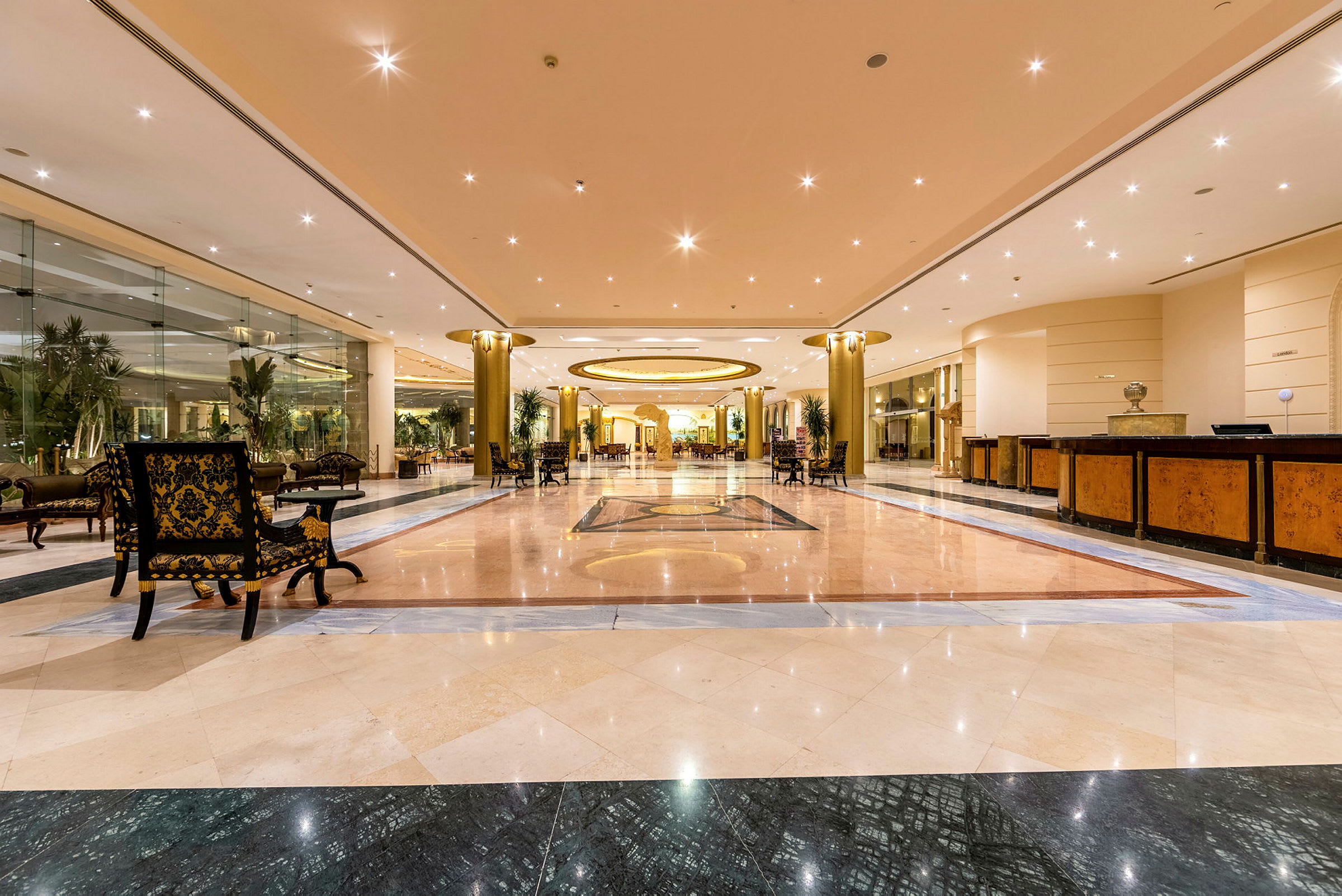Interiør af en hotellobby med marmorgulv og loftsbelysning. (AI-genereret tekst)