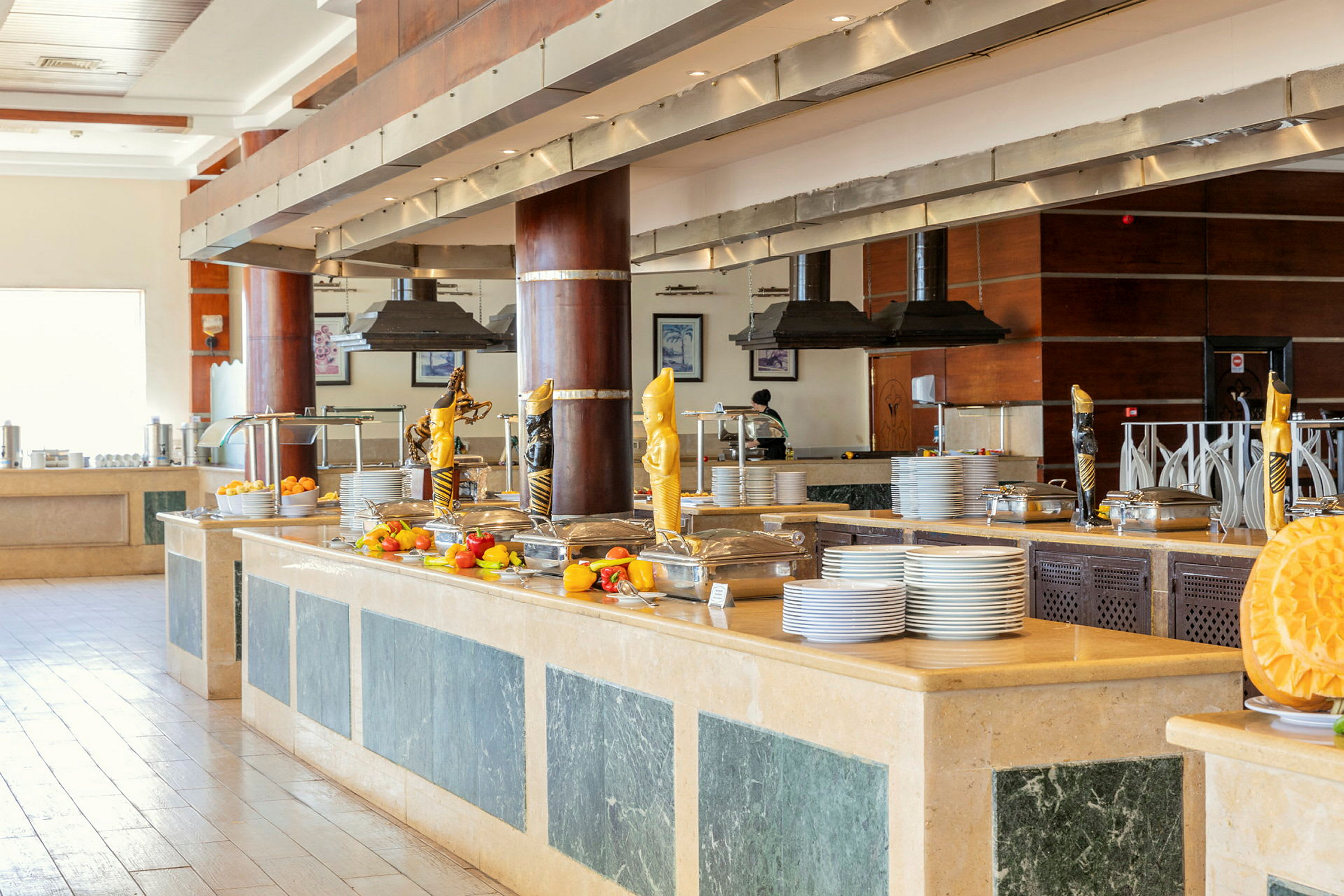 En buffet med tallerkener og skåle, dekoreret med frugt og statuer. (AI-genereret tekst)