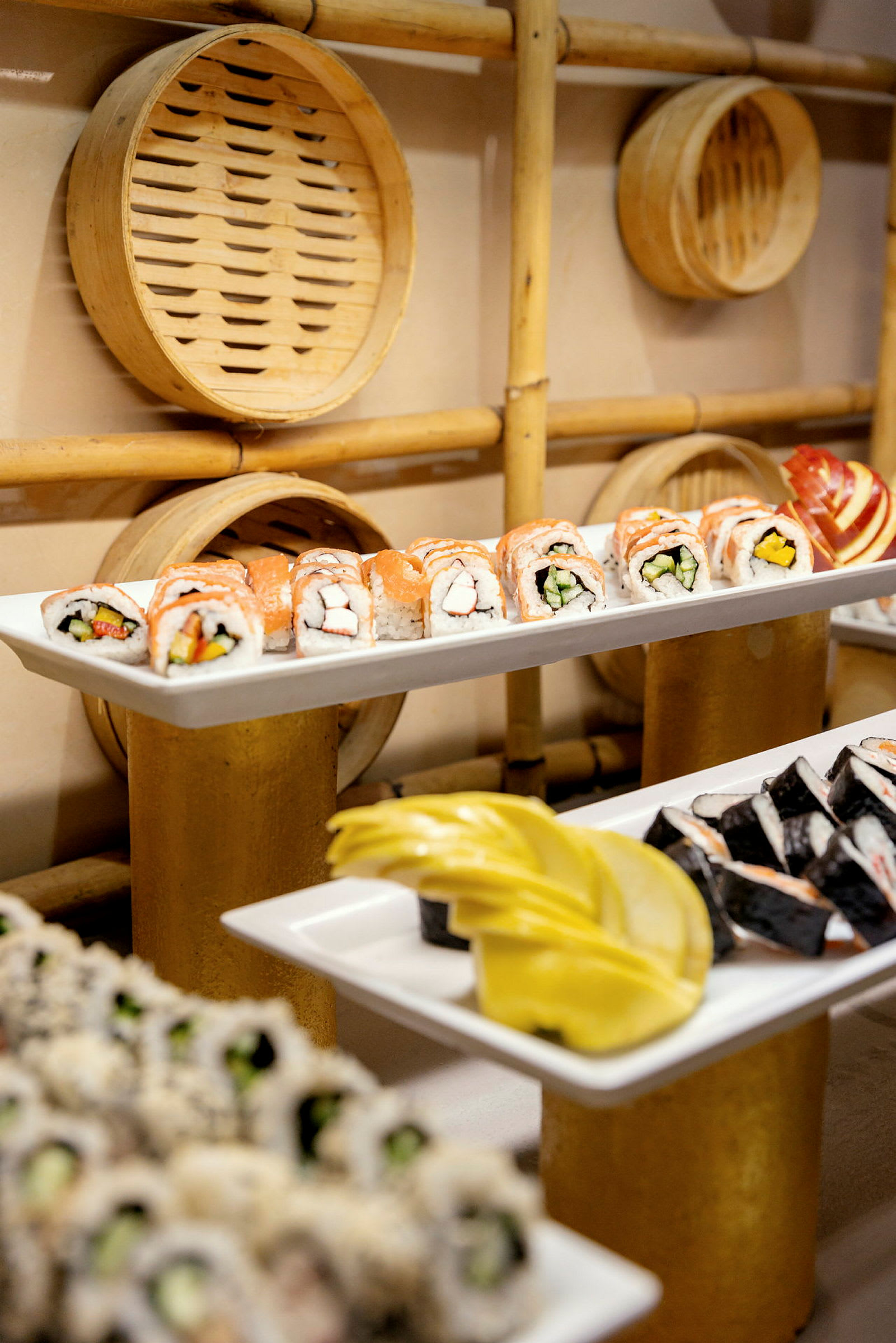 Tallerkener med sushi og dekorationer i bambus på bagvæggen. (AI-genereret tekst)
