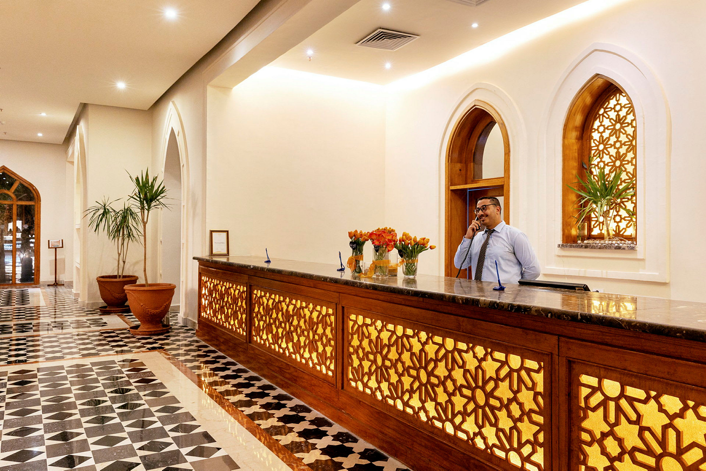 Hotellets lobby med reception og dekorative vinduer. (AI-genereret tekst)