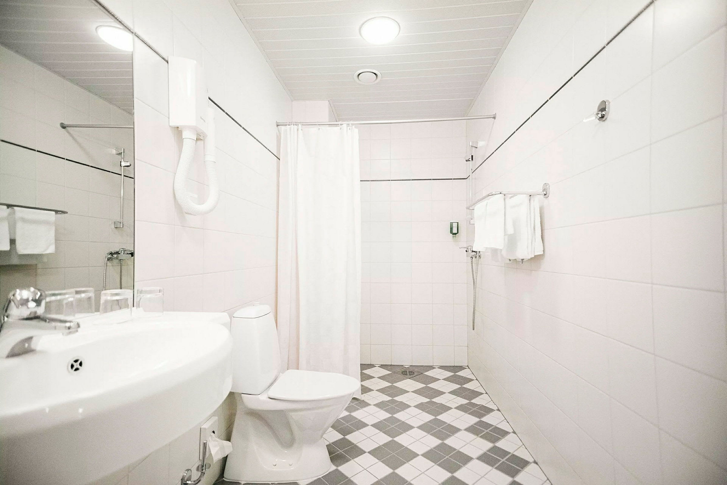 Hotelbadeværelse med toilet, vask og bruser. (AI-genereret tekst)