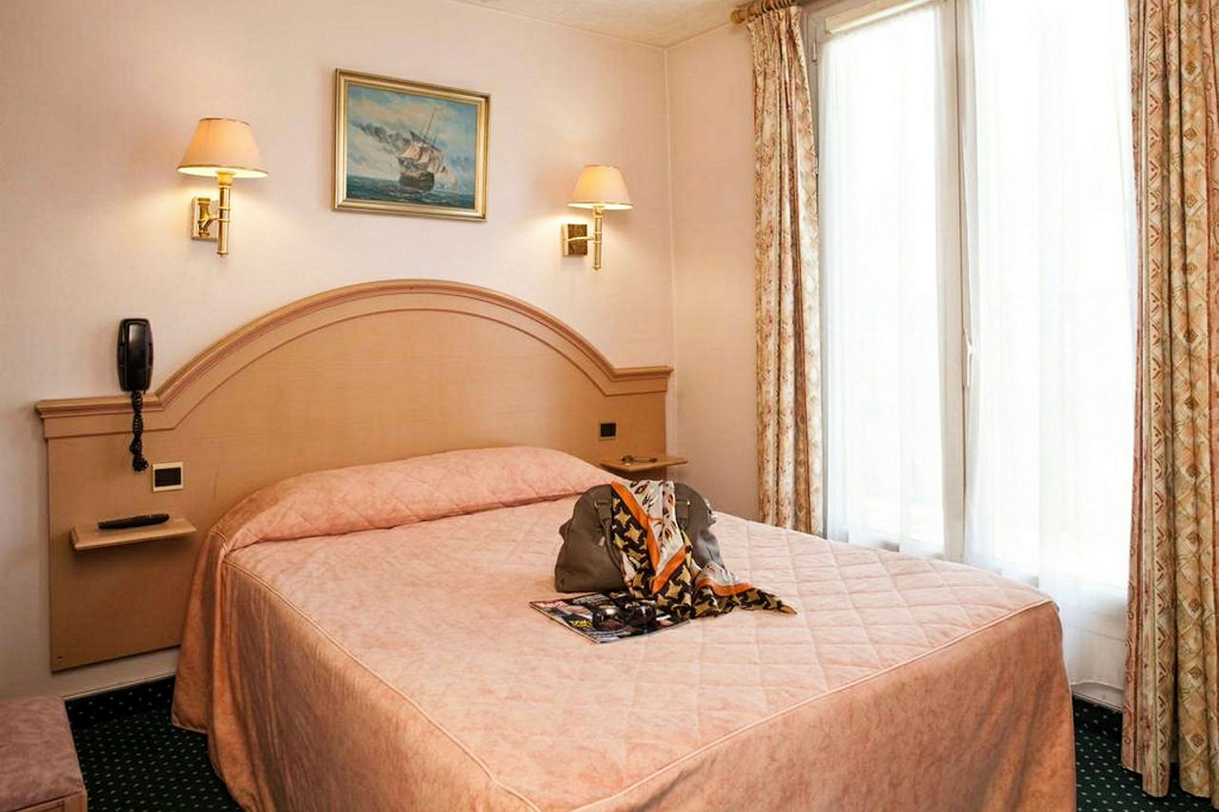 Hotelværelse med en dobbeltseng, beige interiør og gardiner samt et billede på væggen. (AI-genereret tekst)
