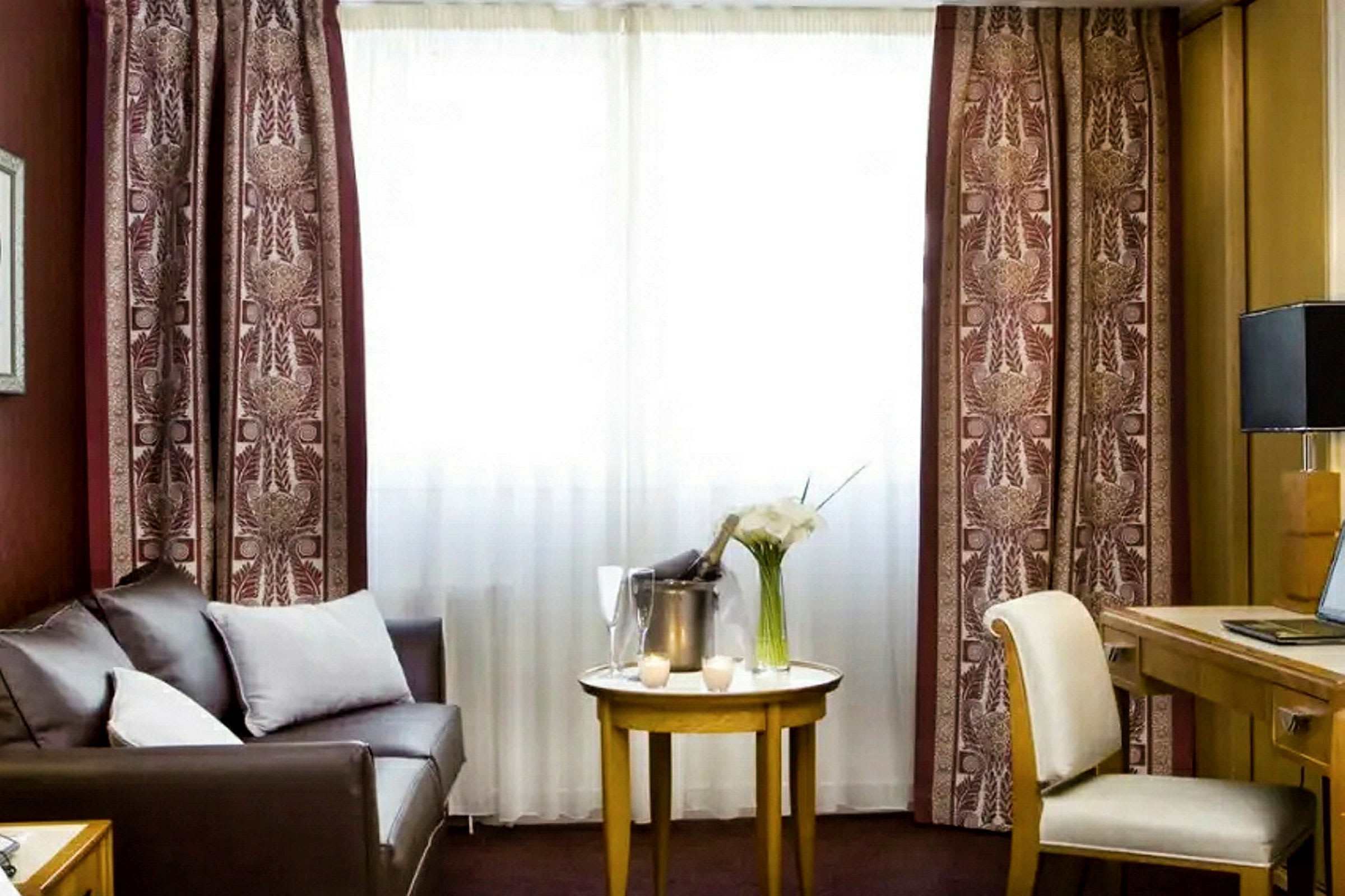 Et hotelværelse med en sofa, et bord og en arbejdsstation. (AI-genereret tekst)