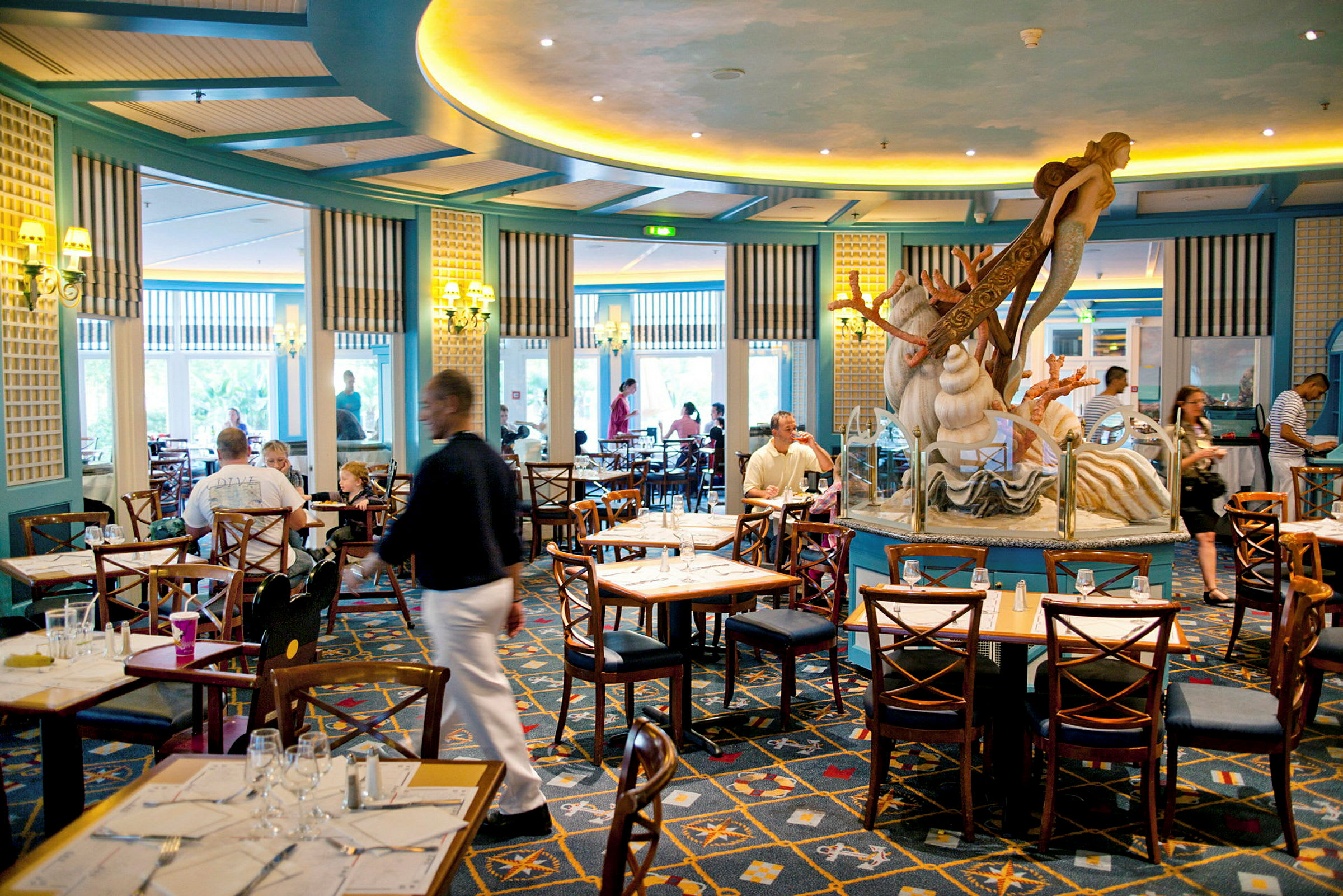 En restaurant med siddepladser og en dekoration i form af en havfigur i midten. (AI-genereret tekst)