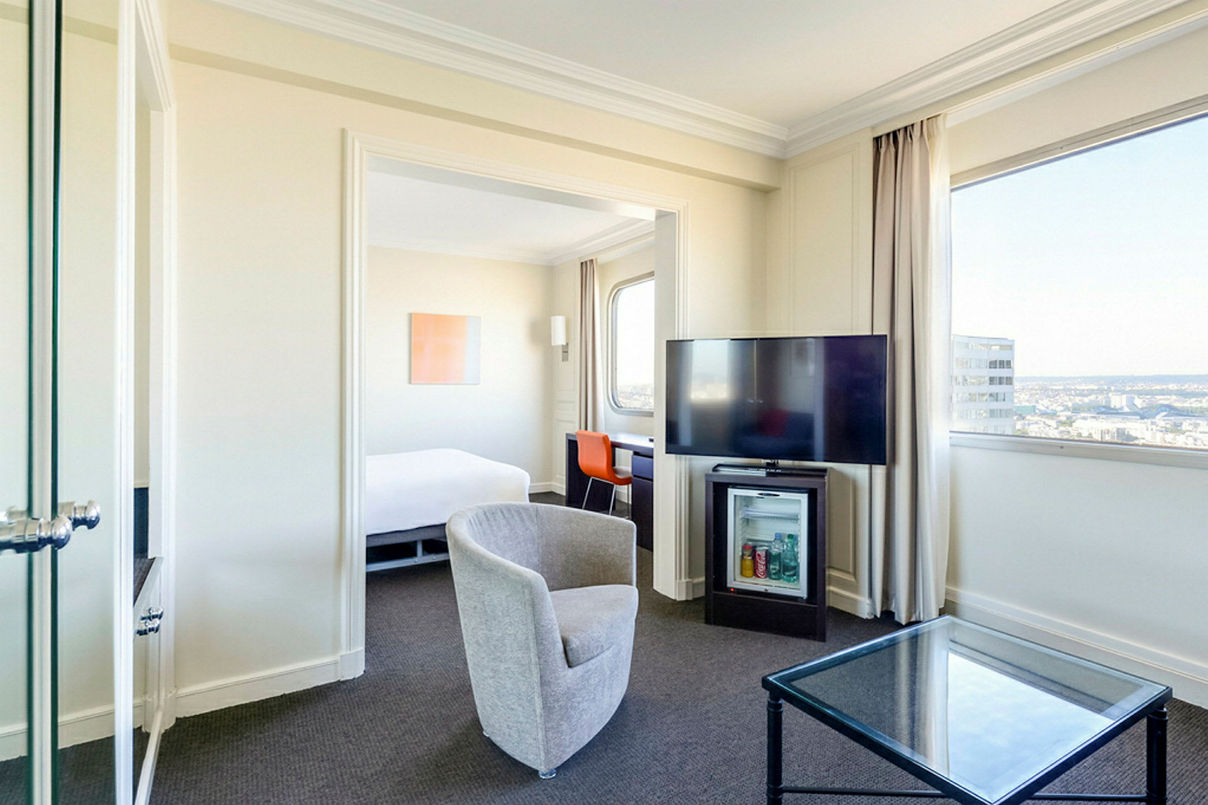 Hotelværelse med siddeområde, tv og udsigt. (AI-genereret tekst)