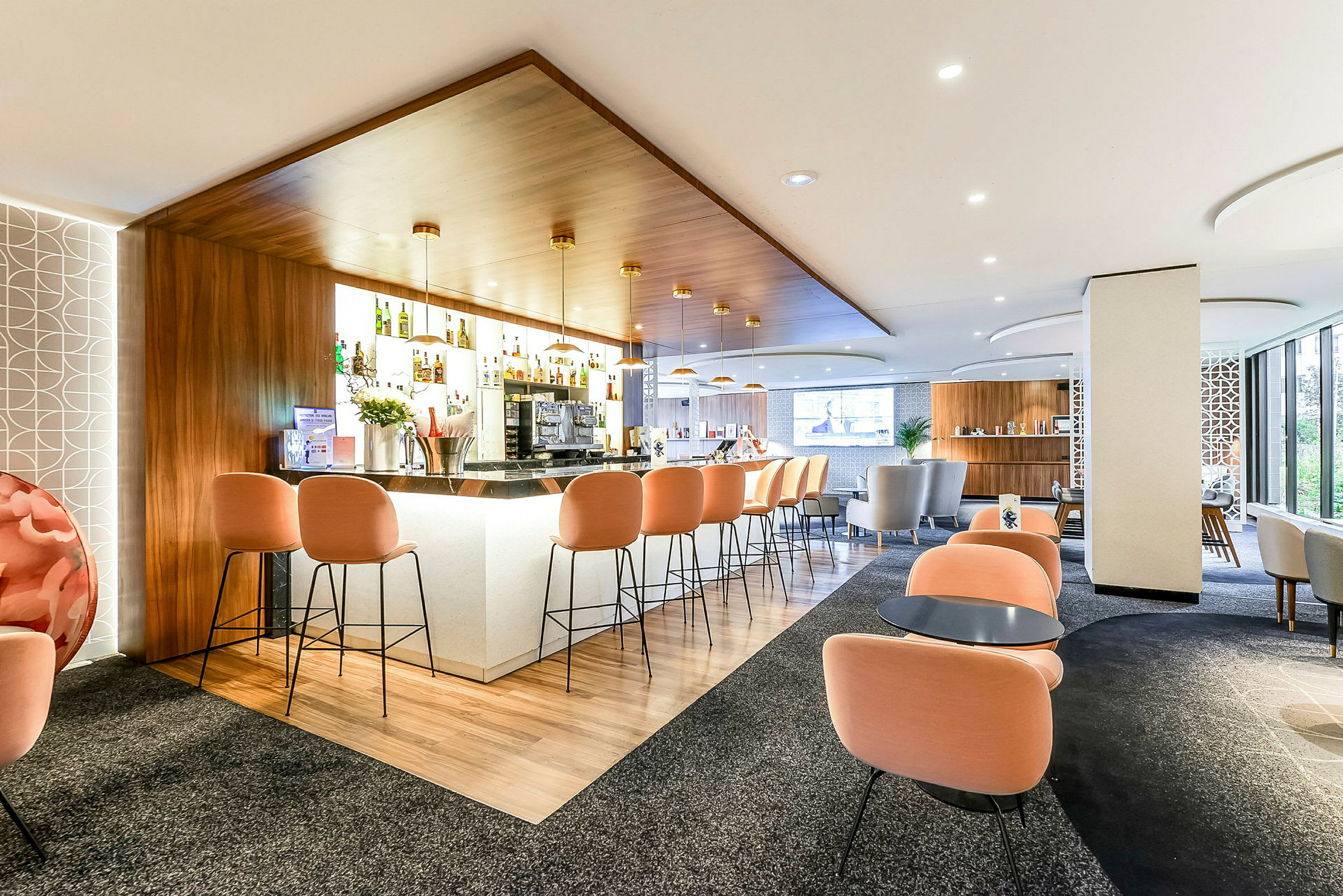En moderne hotelbar med orange stole og et stilrent design. (AI-genereret tekst)
