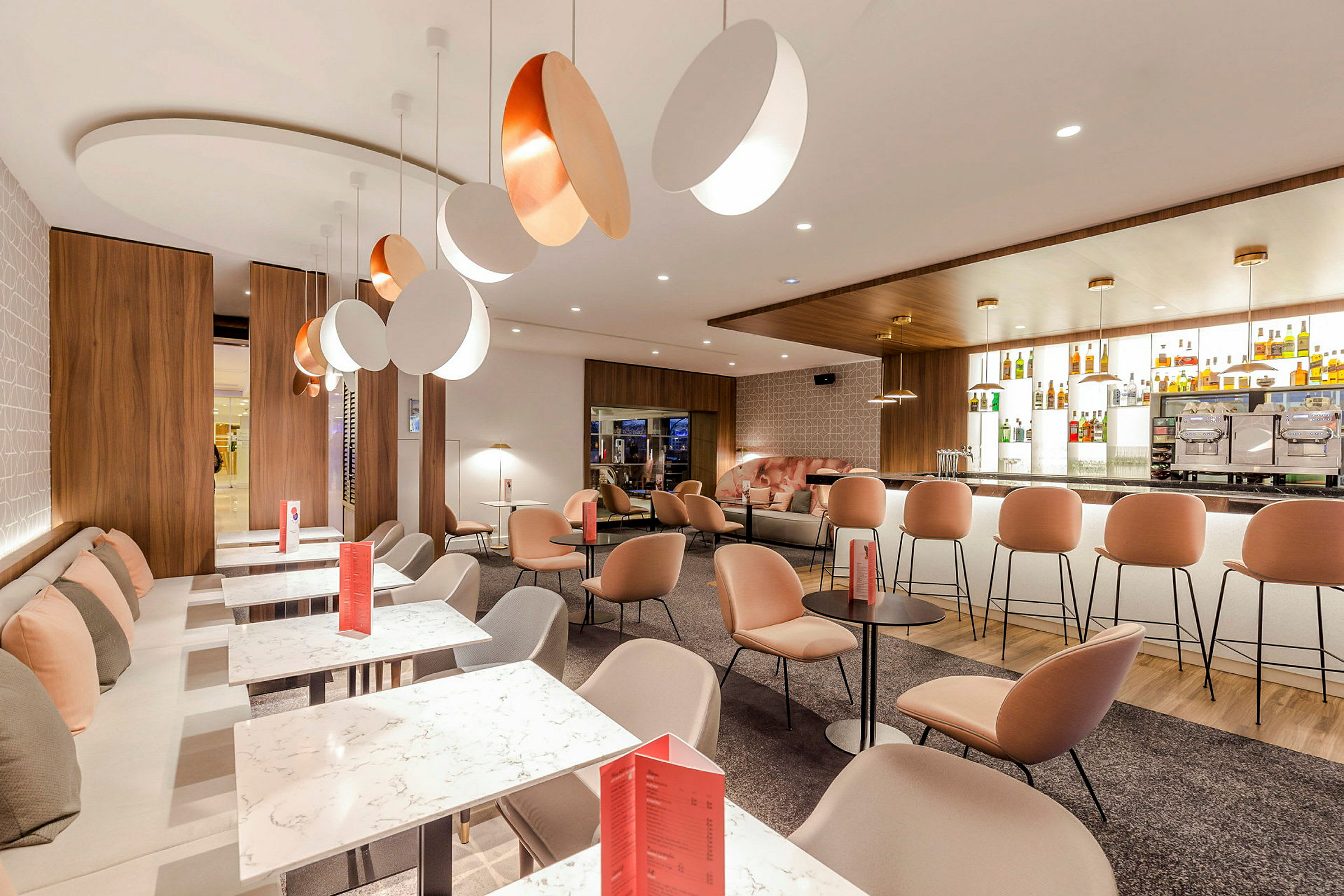 Billede af en moderne lounge med komfortable siddepladser, marmorborde og en elegant bardisk. (AI-genereret tekst)