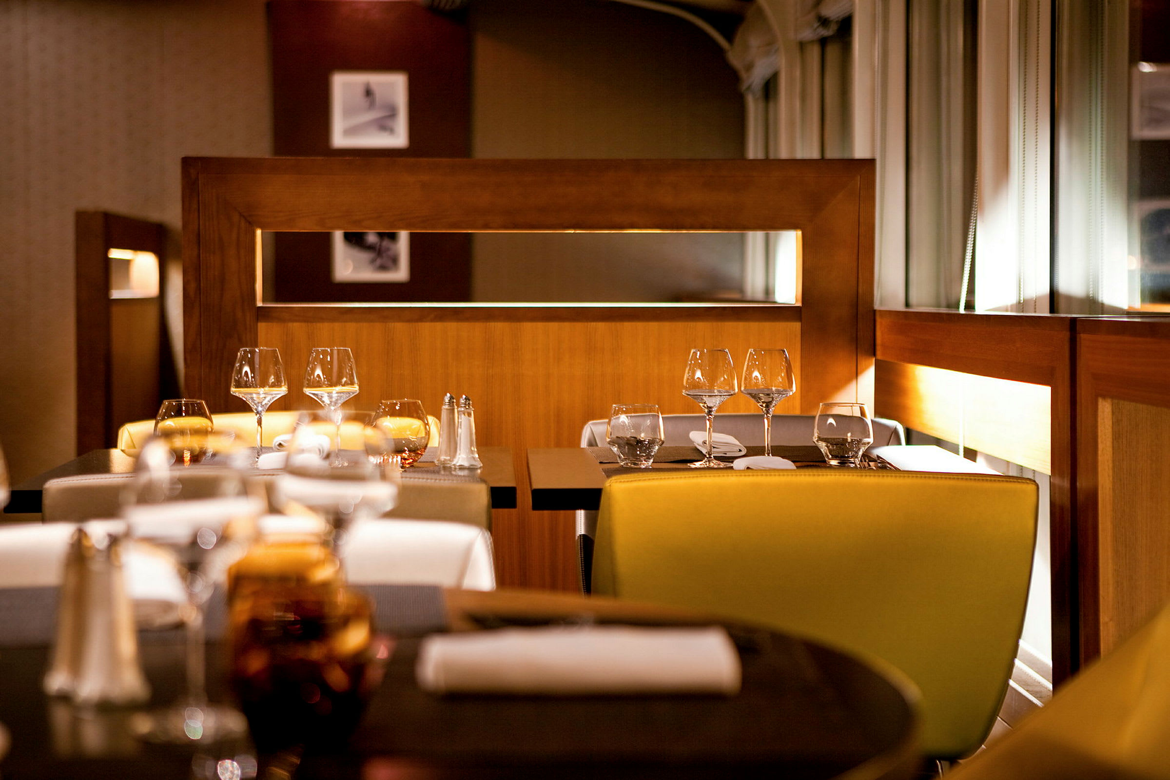 En elegant restaurant med dækkede borde og stole. (AI-genereret tekst)
