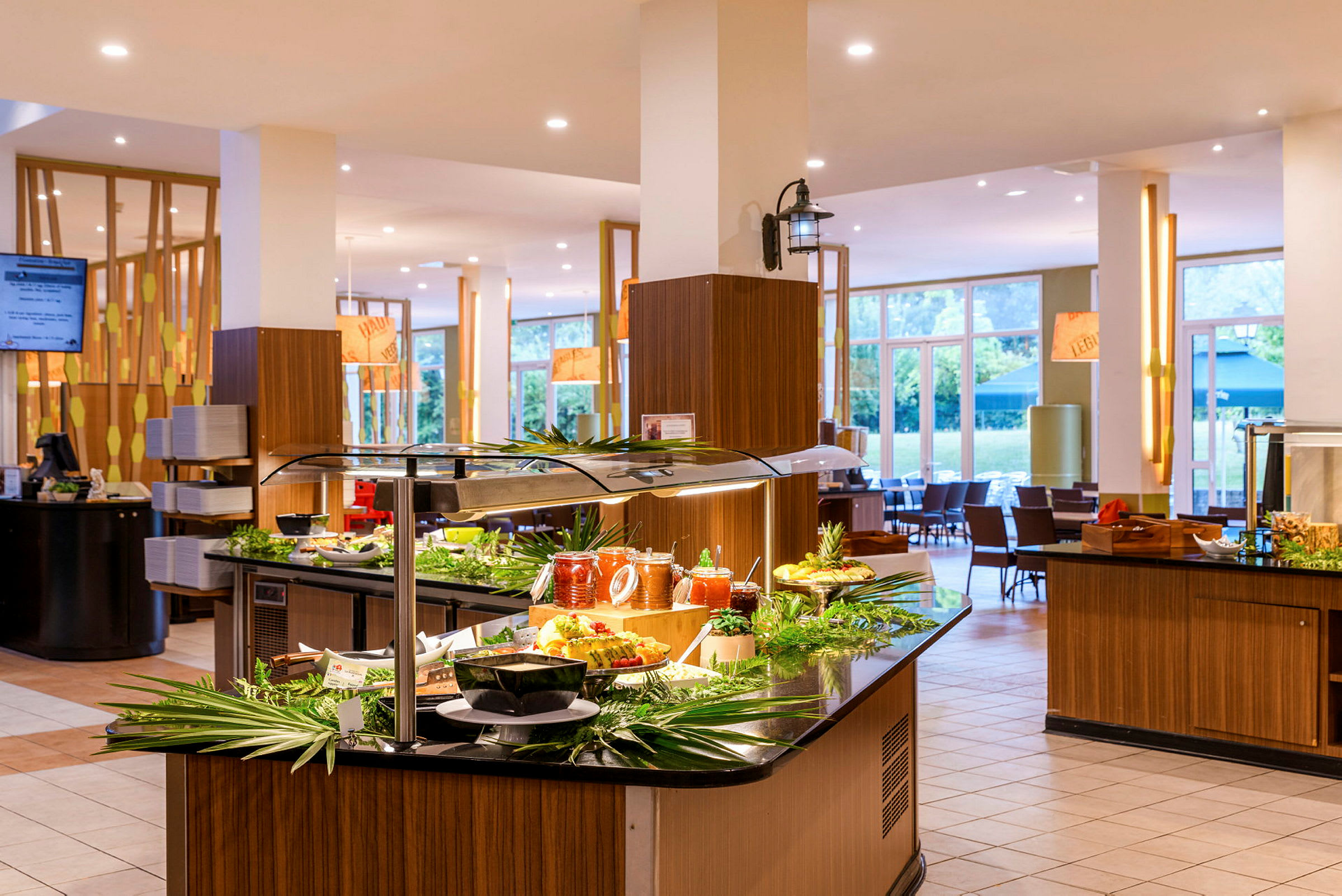 En buffet i et lyst og moderne spiseområde med glasvinduer i baggrunden. (AI-genereret tekst)