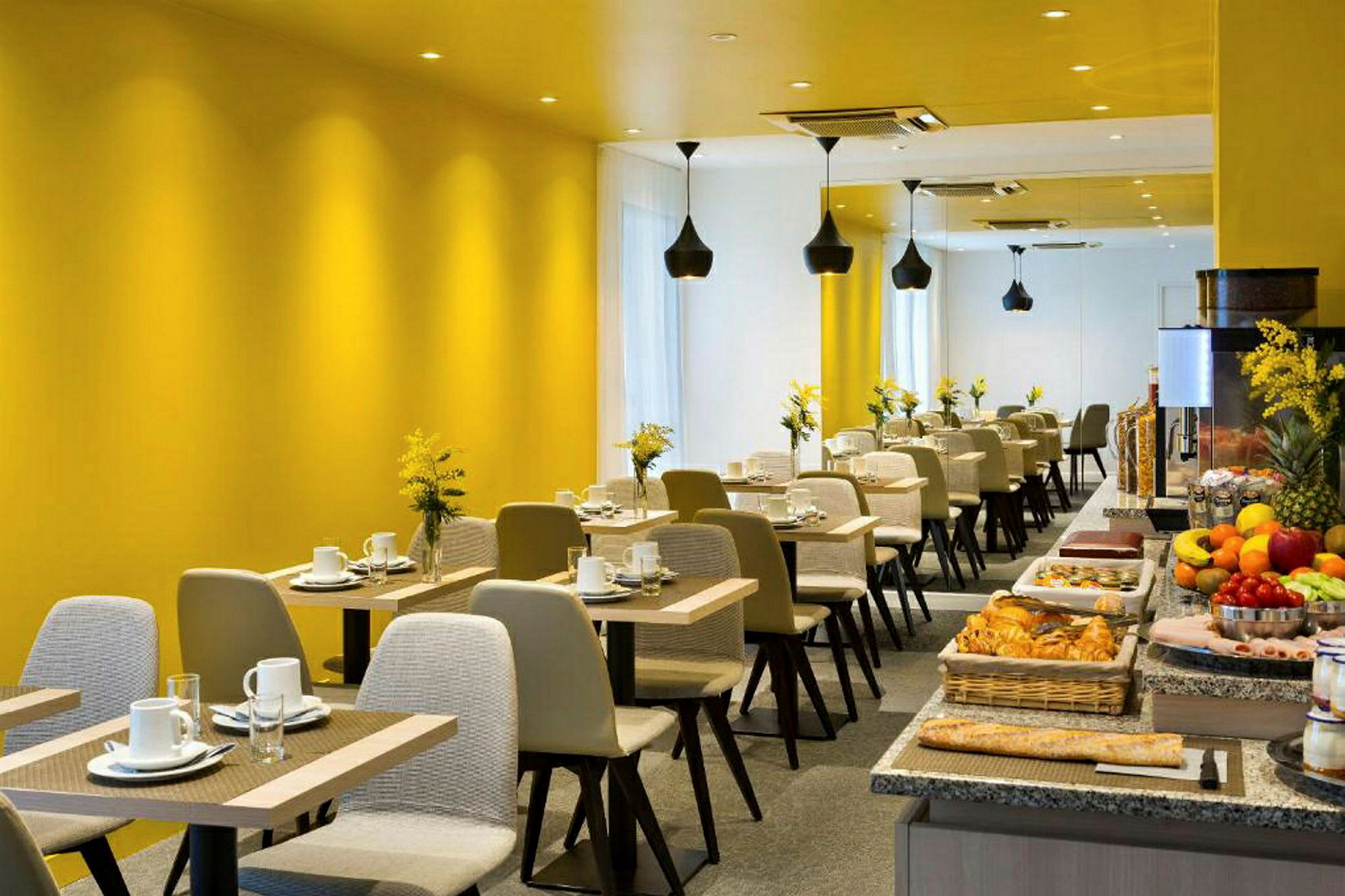 Et moderne restaurantområde med gule vægge, opdækkede borde og en buffet med forskellige madvarer. (AI-genereret tekst)