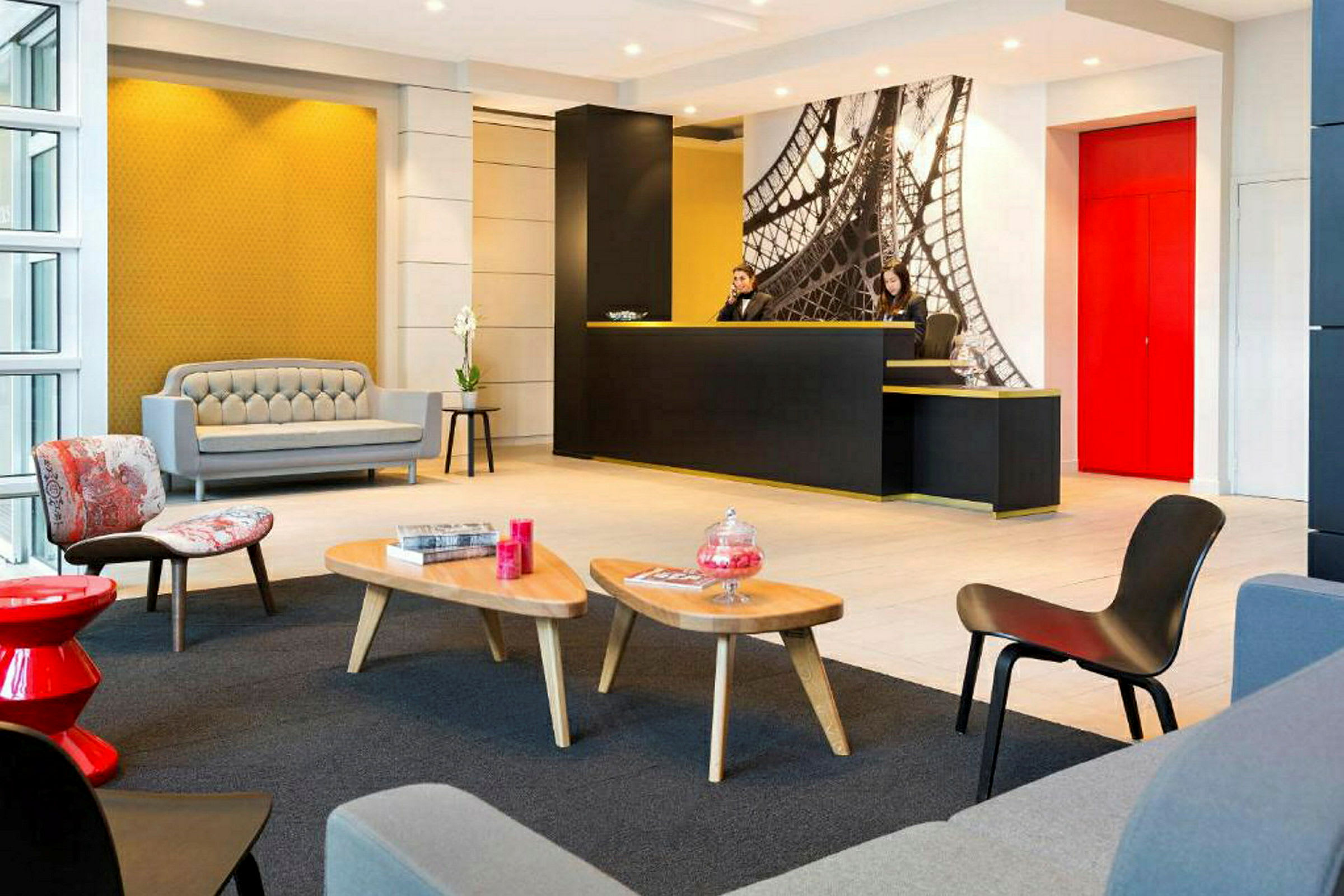 Et moderne hotelreceptionsområde med lys indretning, siddeområde og en receptionsdisk. (AI-genereret tekst)