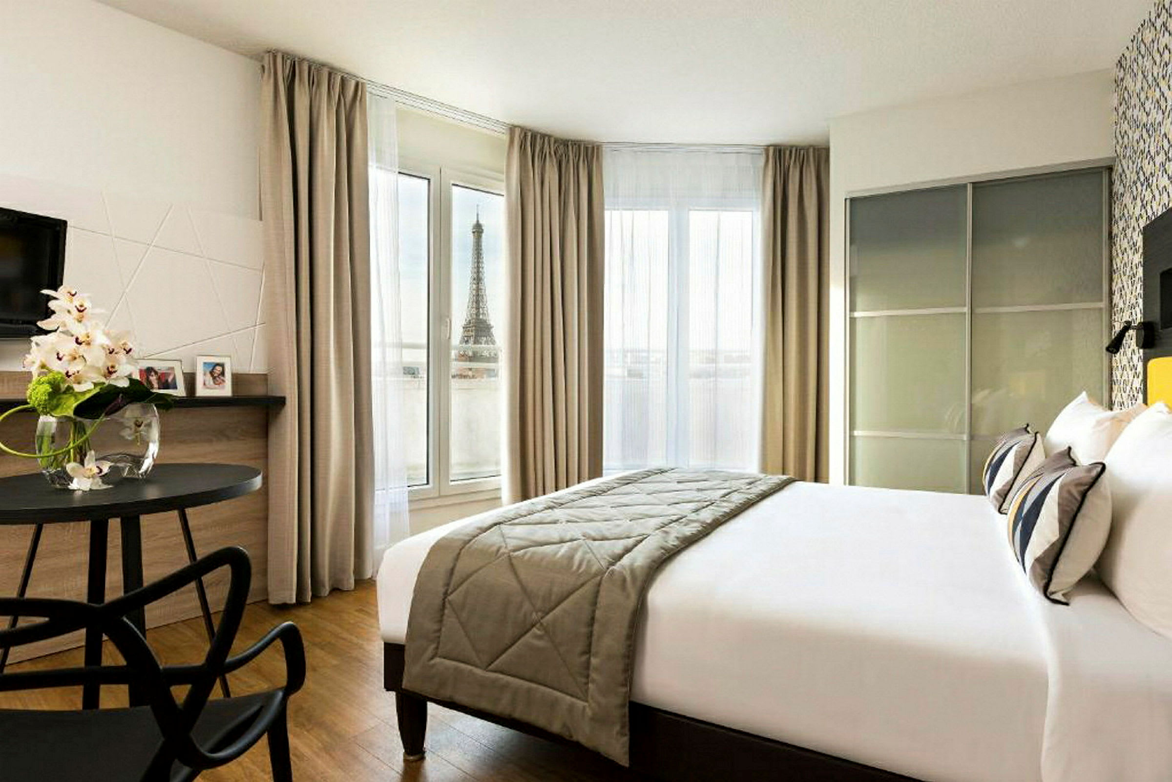 Et hotelværelse med udsigt til Eiffeltårnet fra et vindue. (AI-genereret tekst)