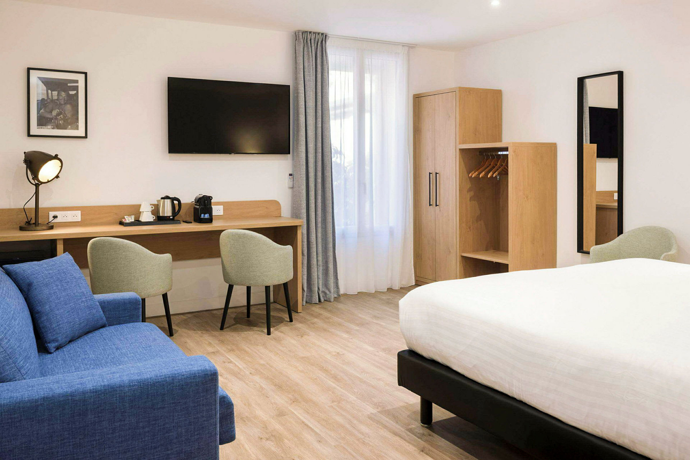 Hotelværelse med dobbeltseng, siddepladser, arbejdsbord og garderobe. (AI-genereret tekst)
