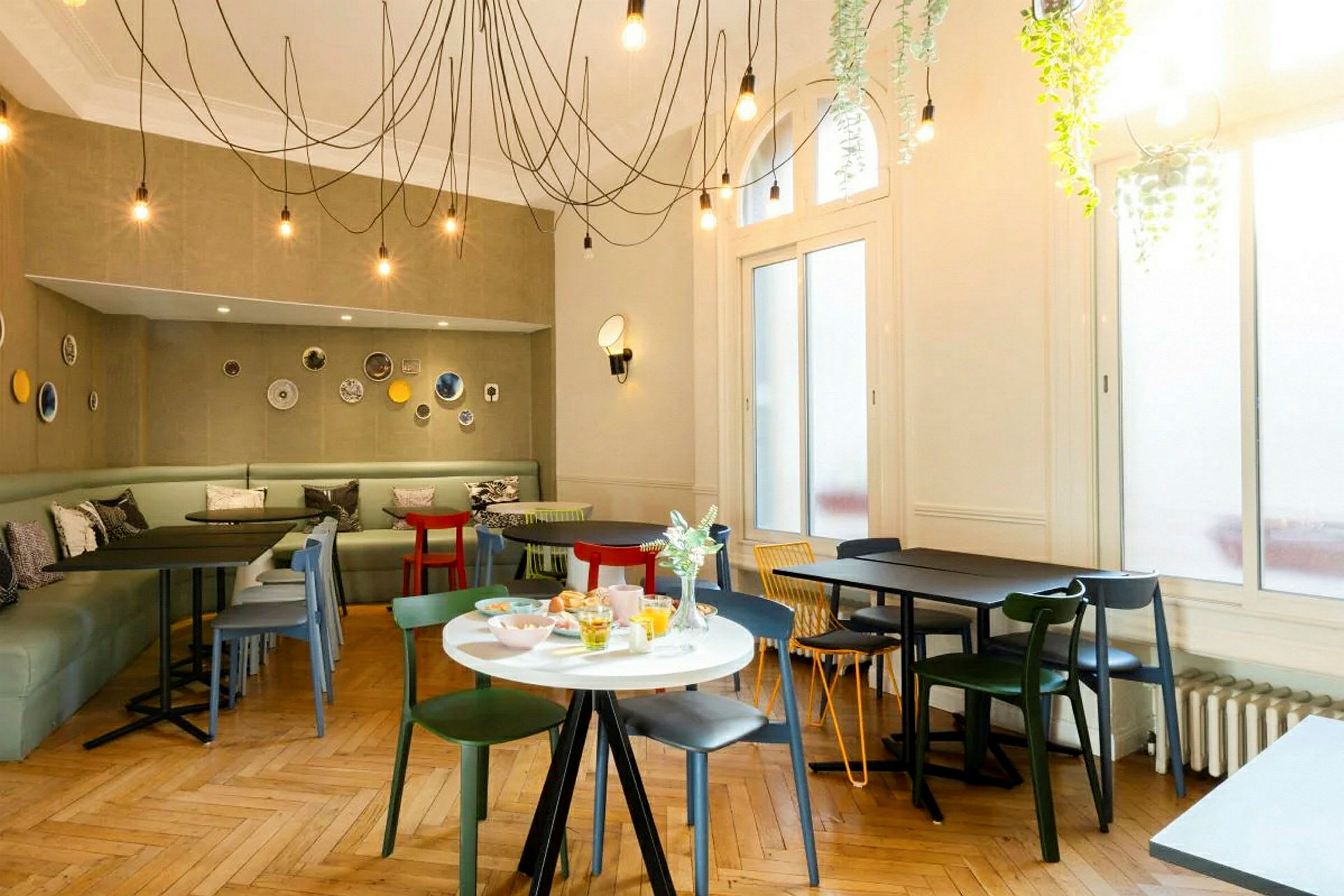 En moderne indrettet café med farverige stole og borde samt dekorationer på væggene. (AI-genereret tekst)