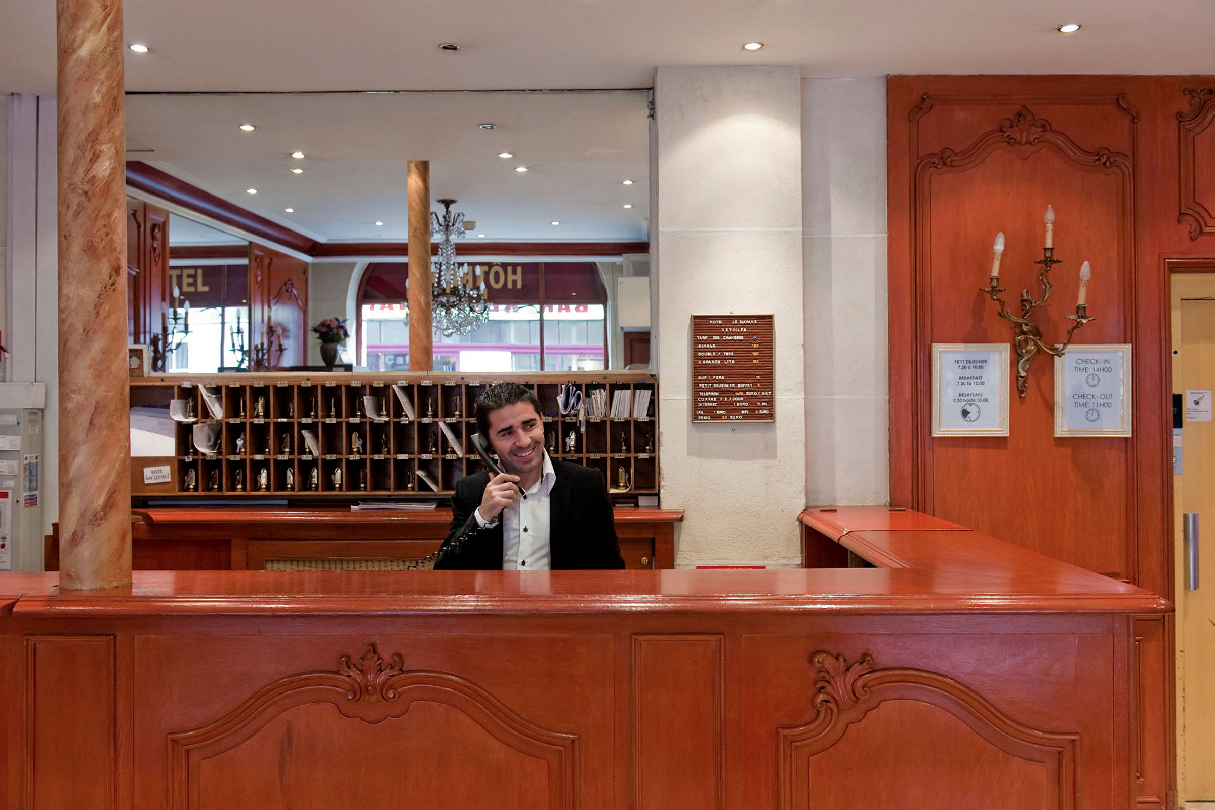 Hotelreception med træinteriør, hylder og spejl i baggrunden. (AI-genereret tekst)