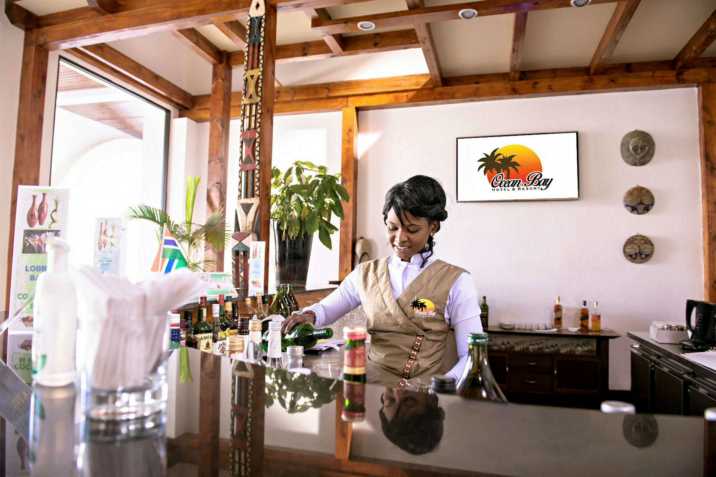 En bartender i uniform forbereder en drink ved en hotelbar. (AI-genereret tekst)