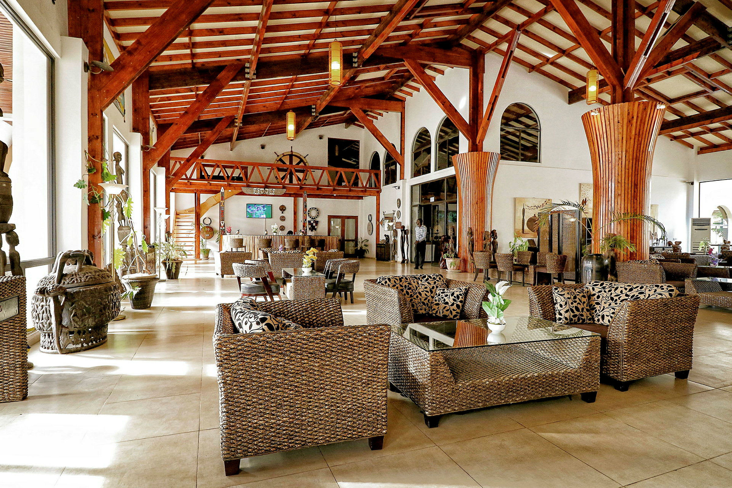 En elegant hotellobby med siddepladser i rattan og højt til loftet. (AI-genereret tekst)