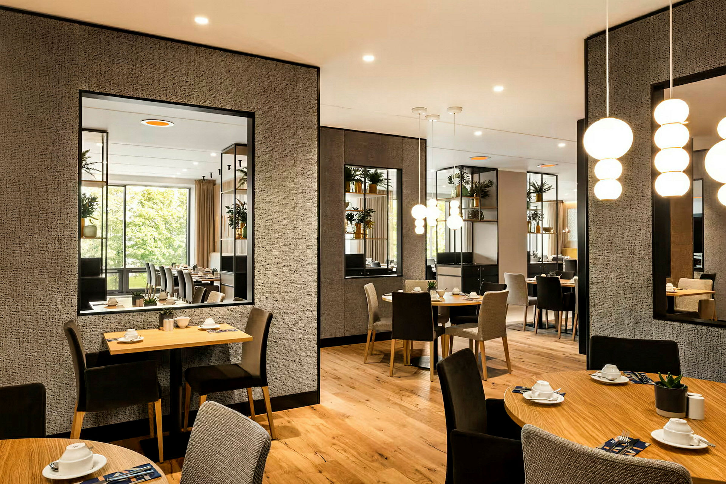 En lyst oplyst café eller restaurant med moderne borde og stole, pynteplanter og spejle på væggene. (AI-genereret tekst)