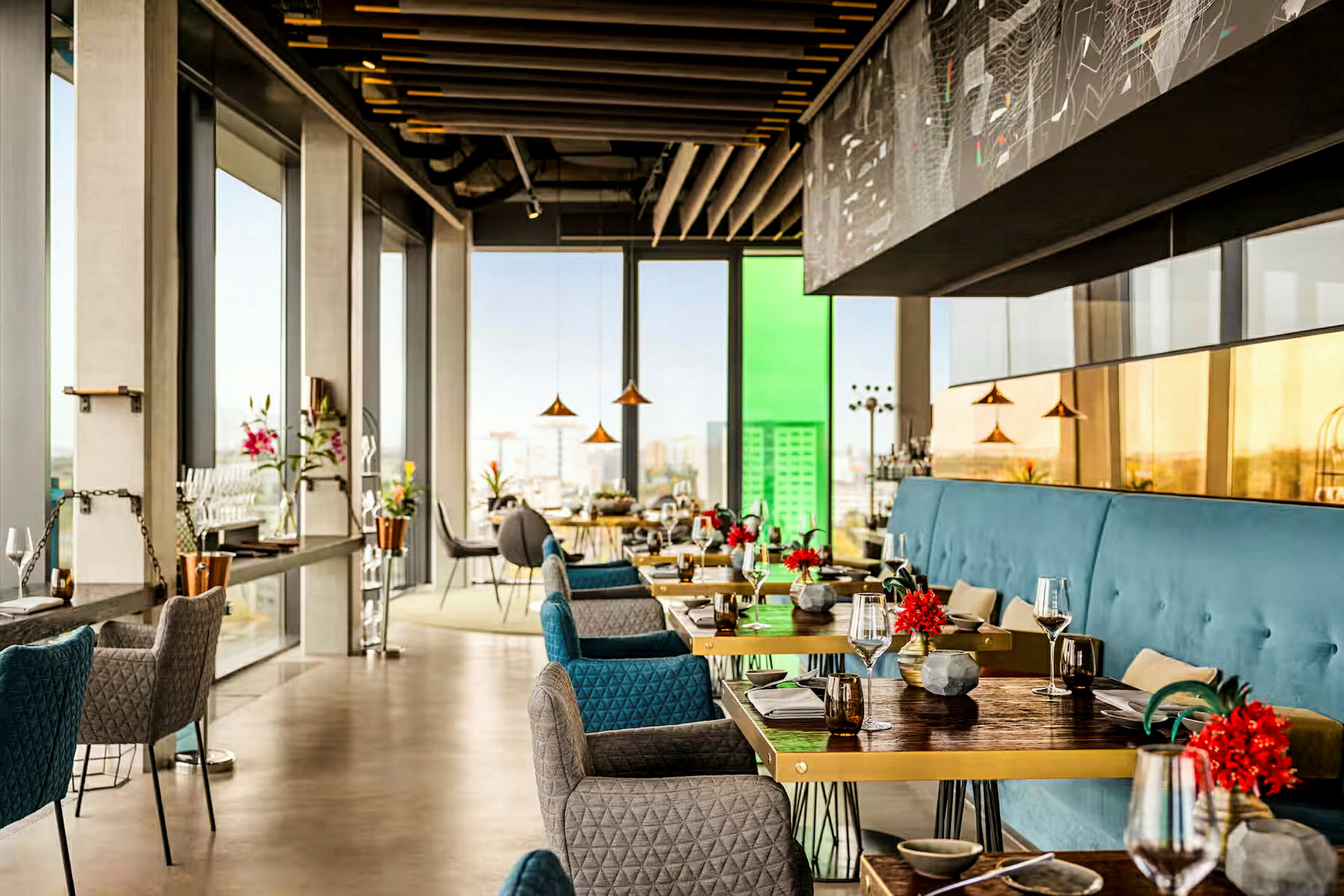 En elegant, moderne restaurant med store vinduer, der giver masser af lys og udsigt over byen. Bordene er dekoreret med blomster. (AI-genereret tekst)