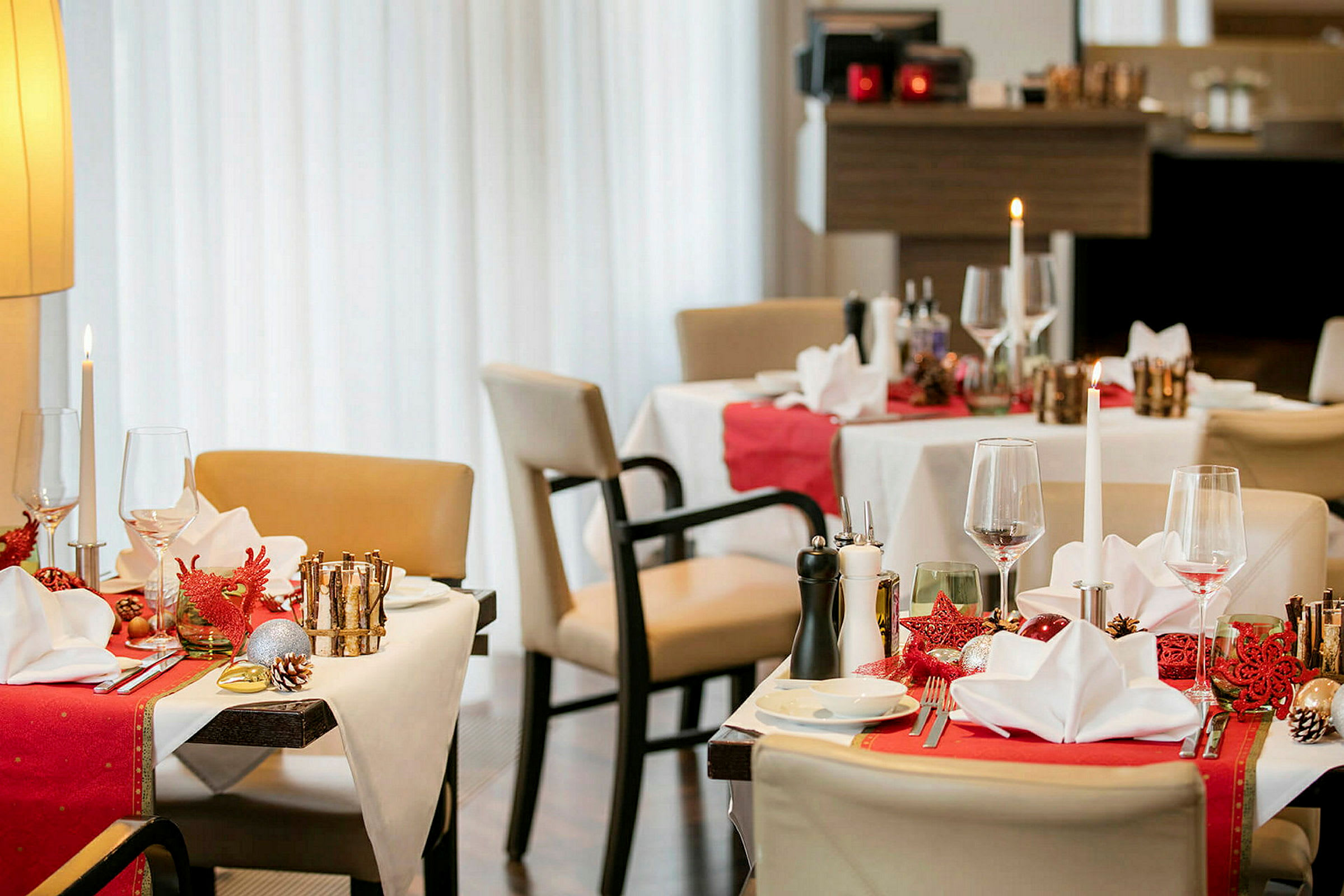 Restaurantbord med juledekorationer, dækket med servietter og glas. (AI-genereret tekst)