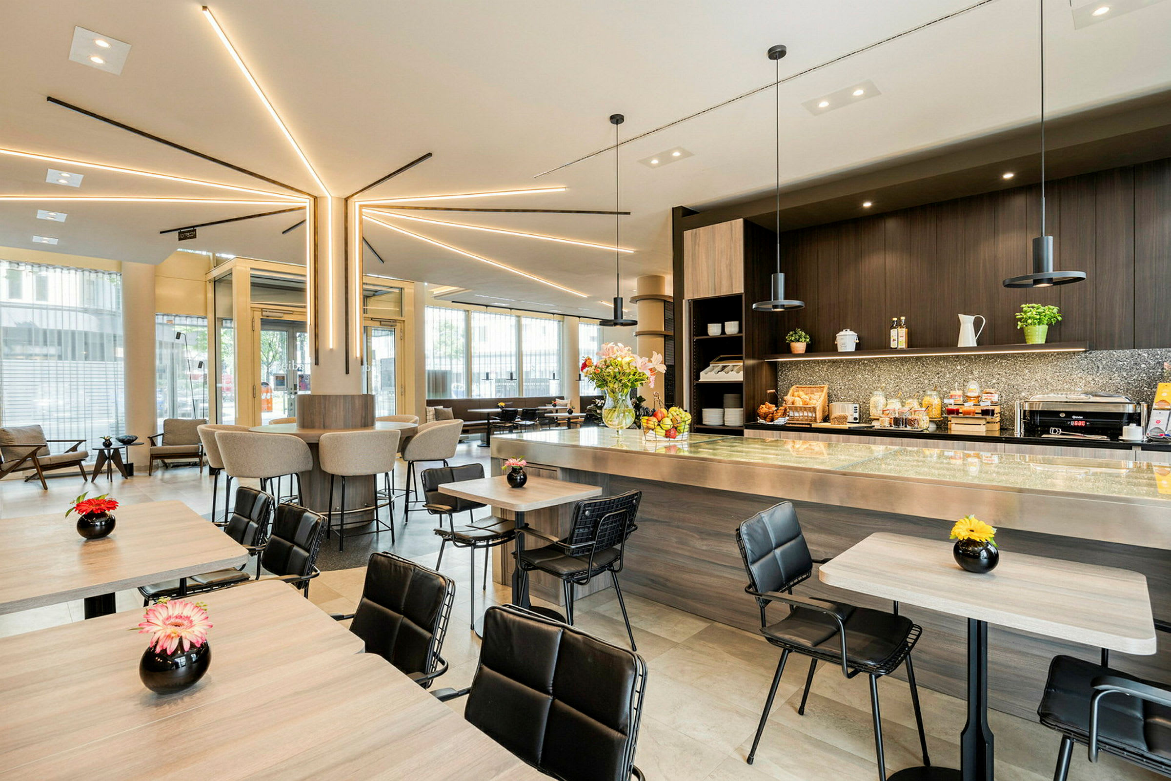 Moderne cafémiljø med siddepladser ved borde og bardisk, dekoreret med blomster. (AI-genereret tekst)