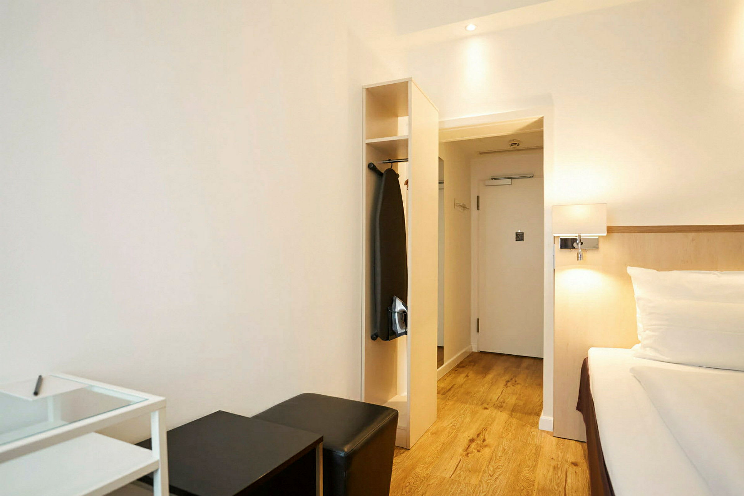 Et hotelværelse med seng, siddepladser og garderobe. (AI-genereret tekst)