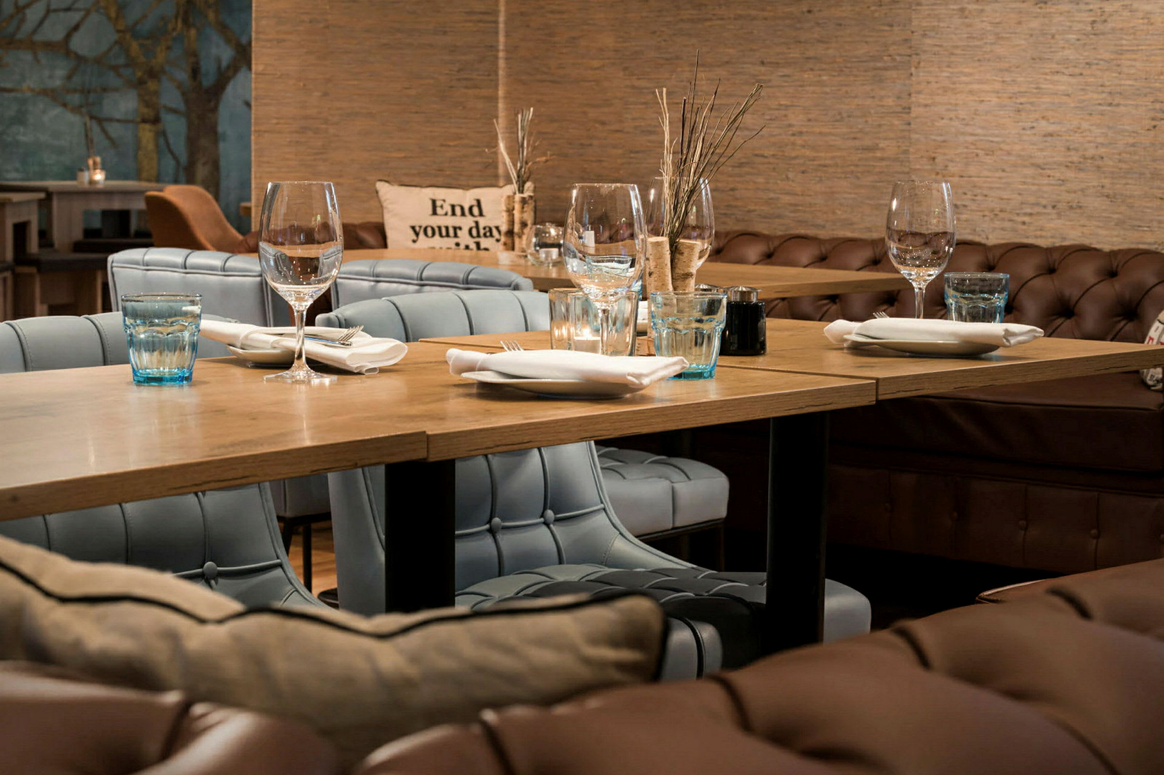 En restaurantinteriør med dækket bord og polstrede stole. (AI-genereret tekst)