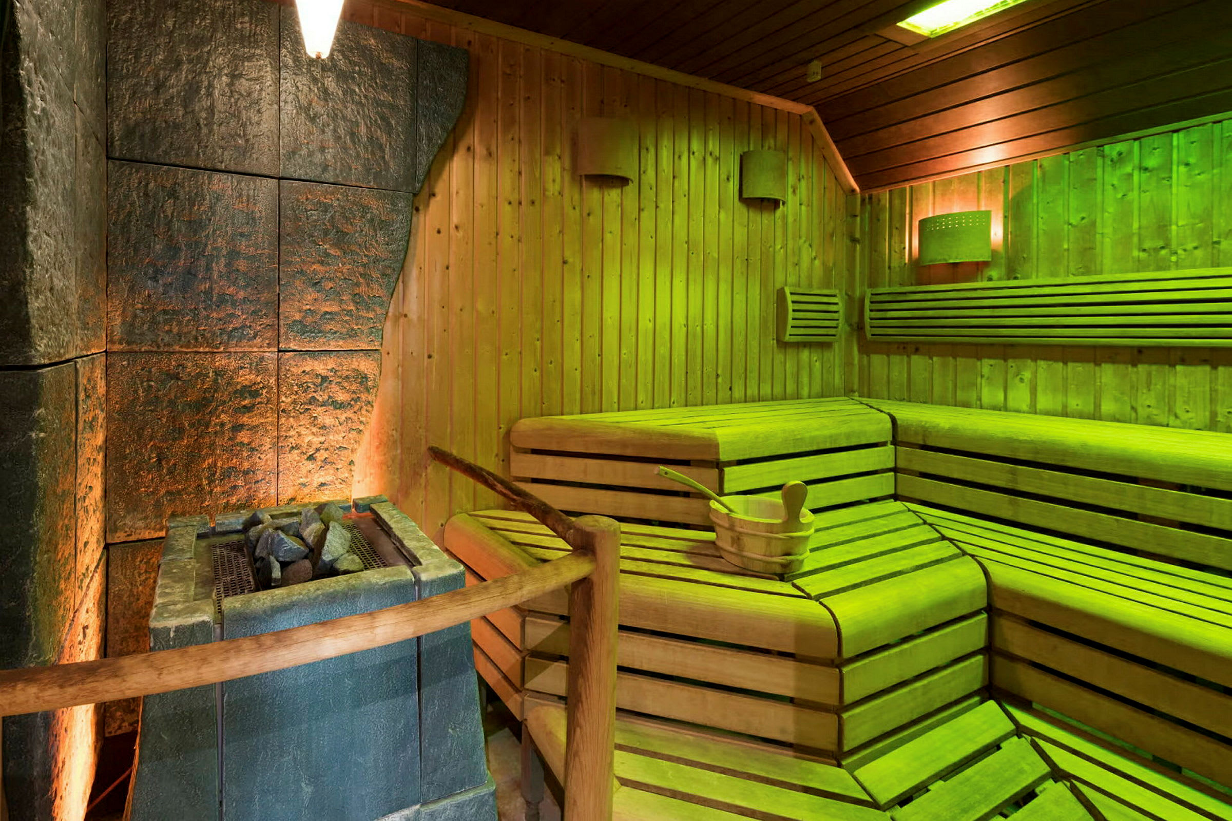 Et billede af en sauna med træbænke og en brændefyret stenovn. (AI-genereret tekst)