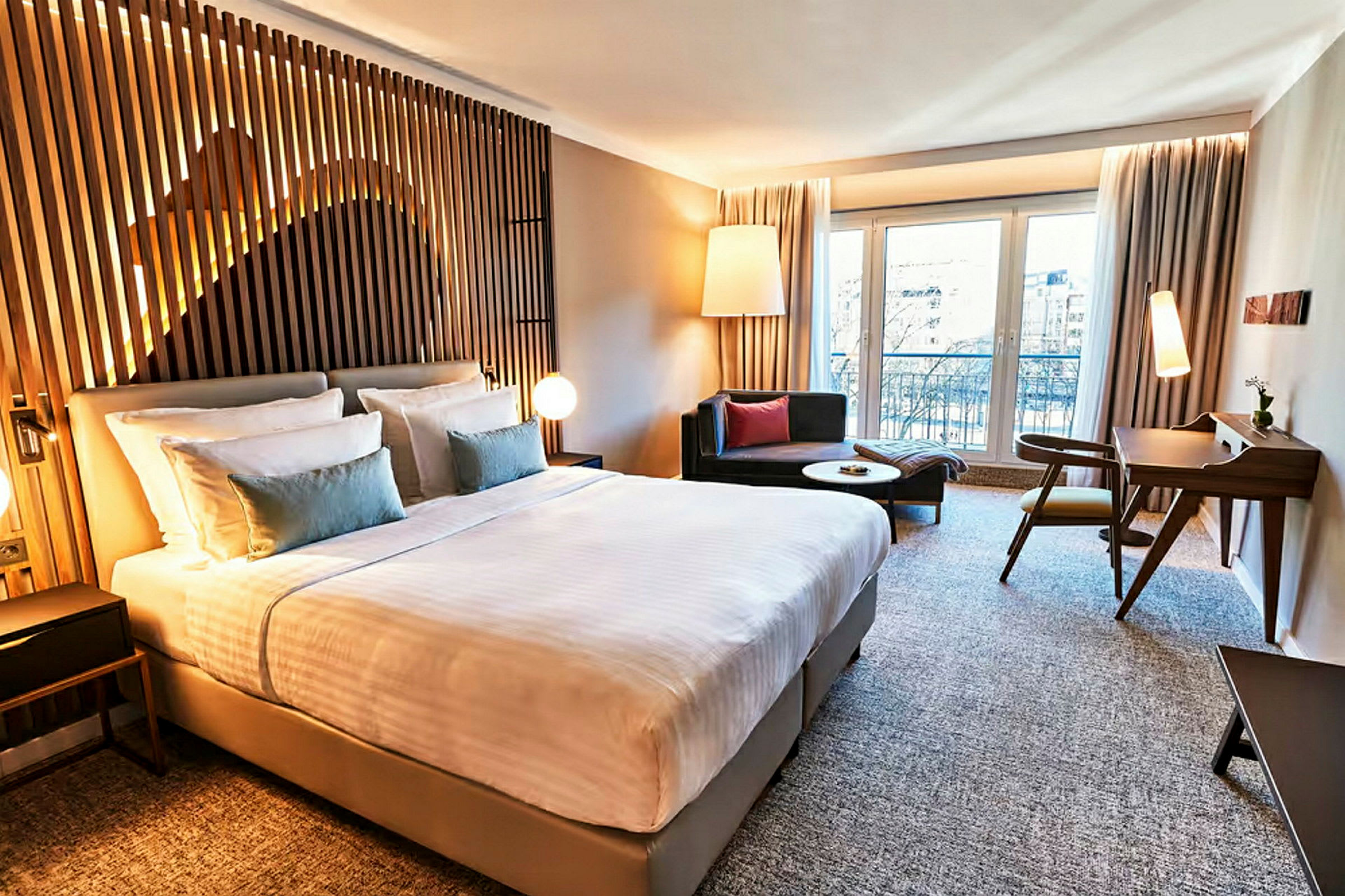 Et moderne hotelværelse med en stor seng, siddepladser og skrivebord. (AI-genereret tekst)