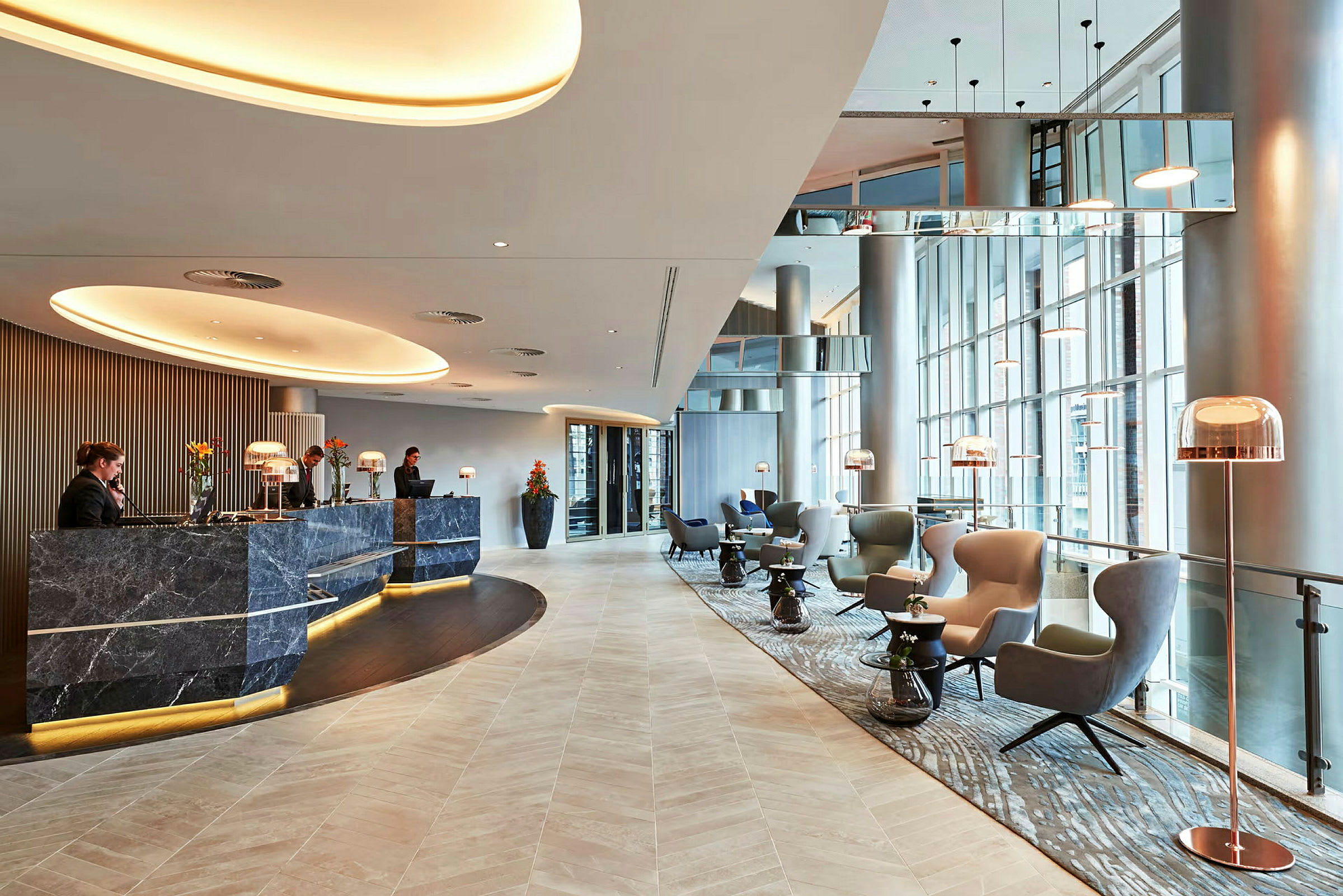 En moderne hotellobby med reception og siddeområder. (AI-genereret tekst)