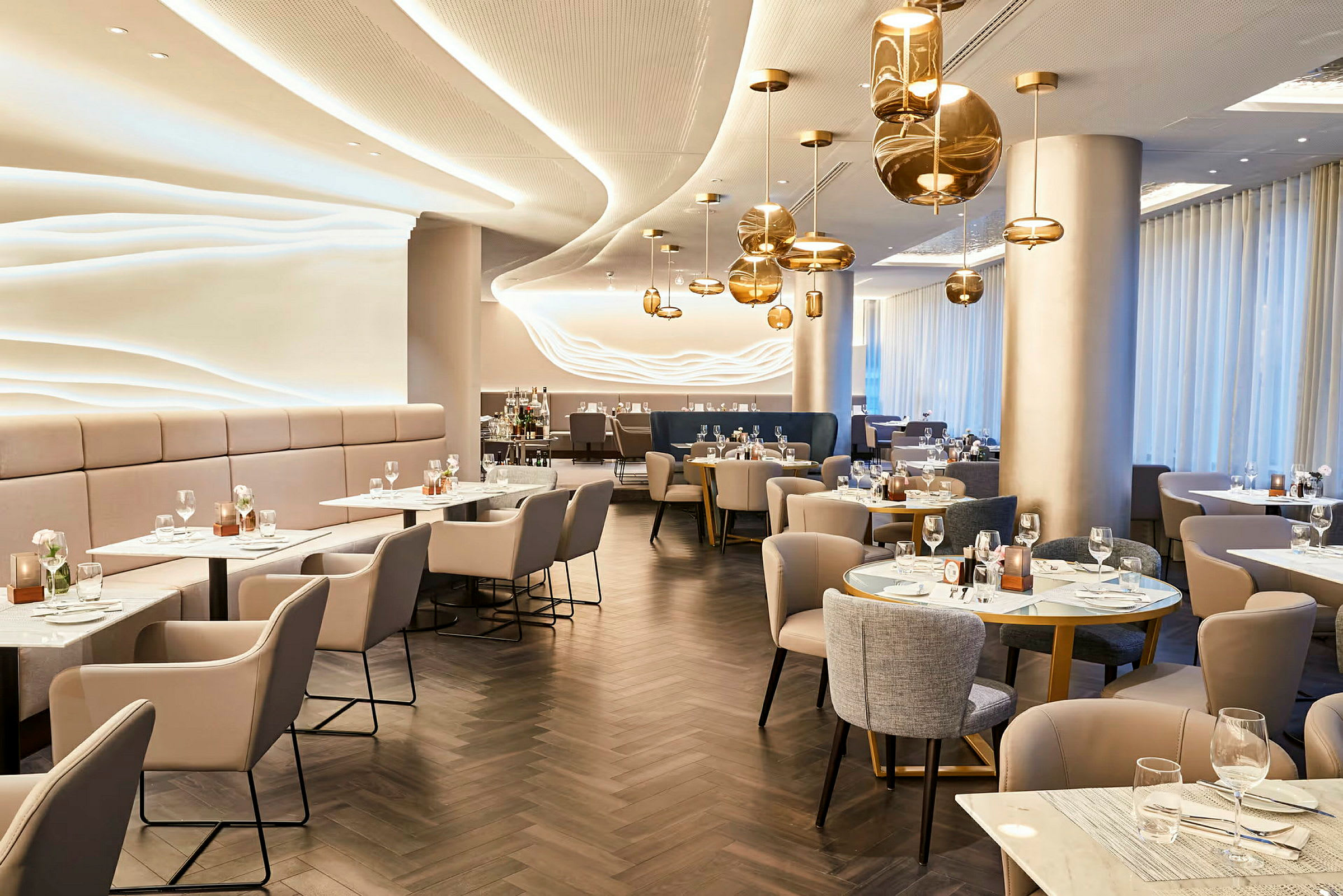 En elegant restaurant med moderne indretning og borde dækket til gæster. (AI-genereret tekst)