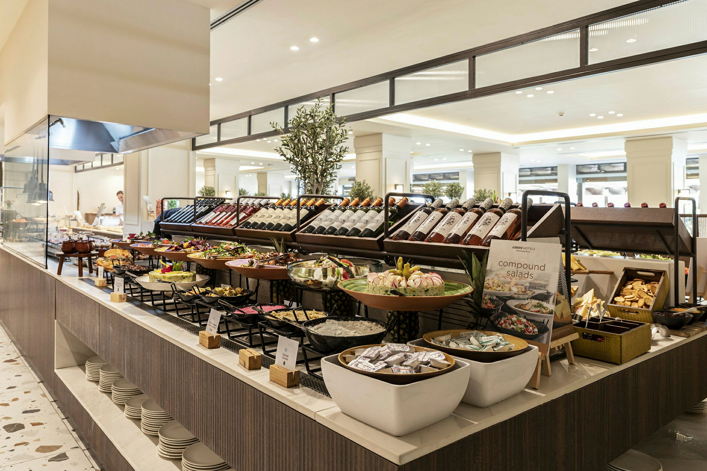En stor buffet med forskellige madmuligheder, herunder salater, brød og drikkeflasker, anrettet i et elegant miljø. (AI-genereret tekst)