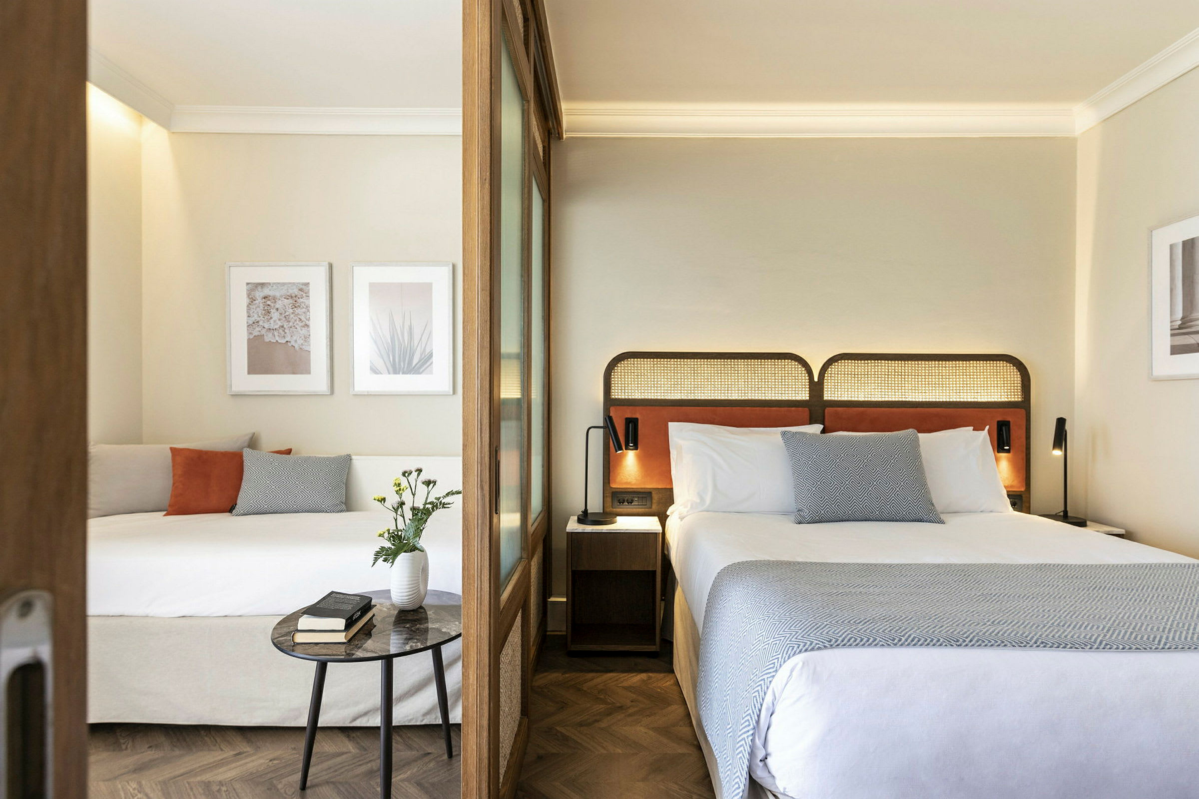 Moderne hotelværelse med to senge, dekorative billeder og indretning. (AI-genereret tekst)